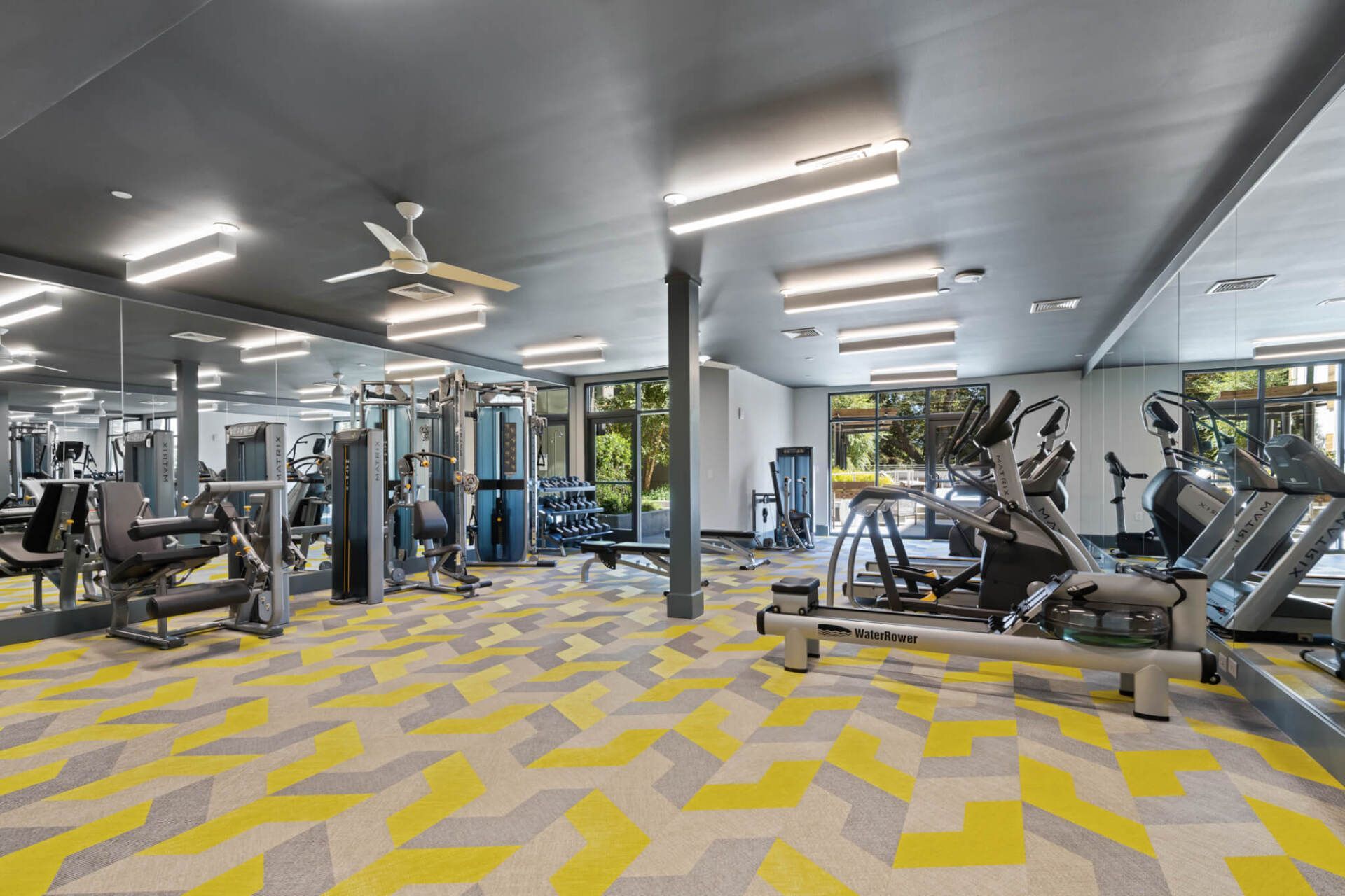 A large gym with a lot of equipment and a yellow floor.