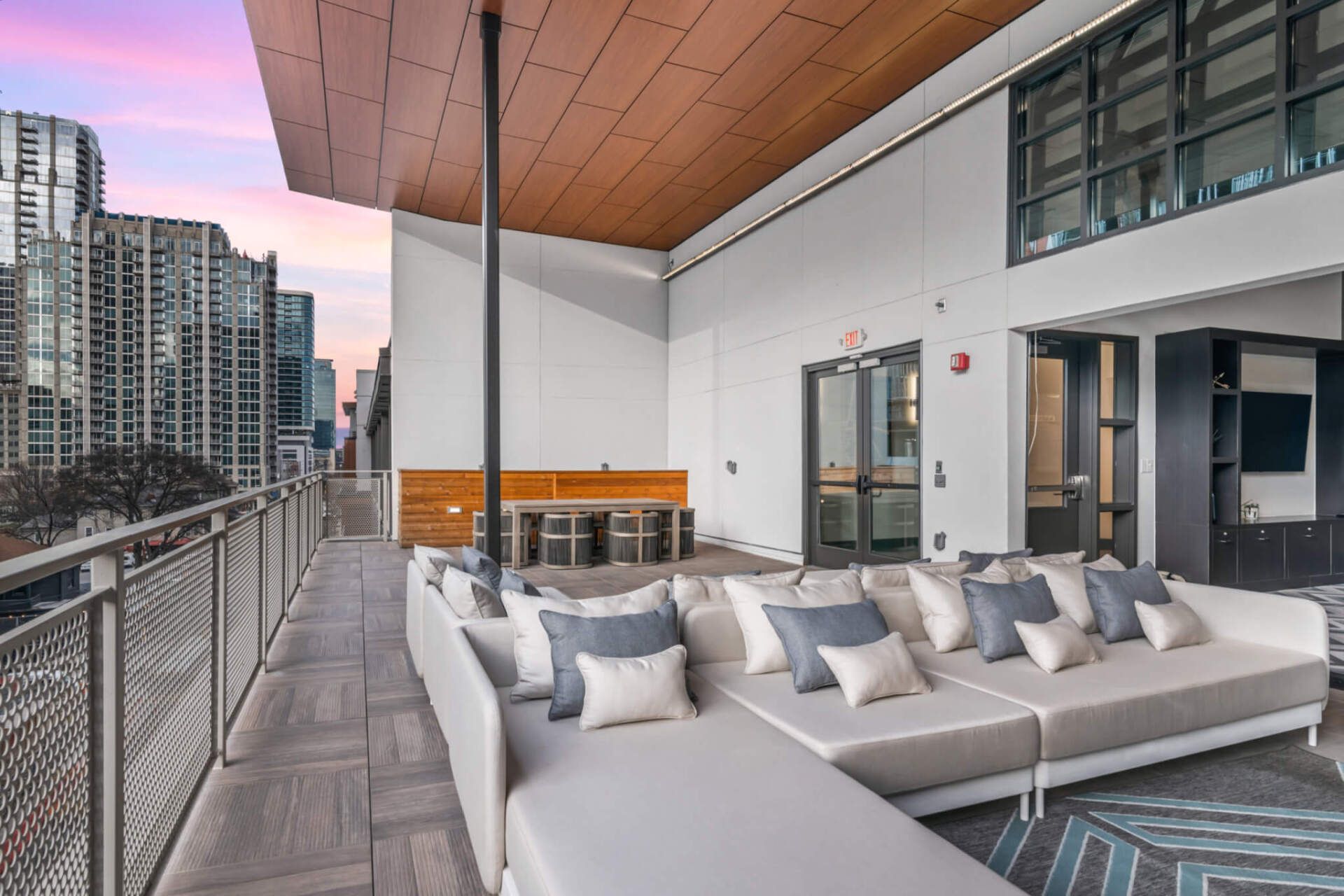 There is a large couch on the balcony with a view of the city.