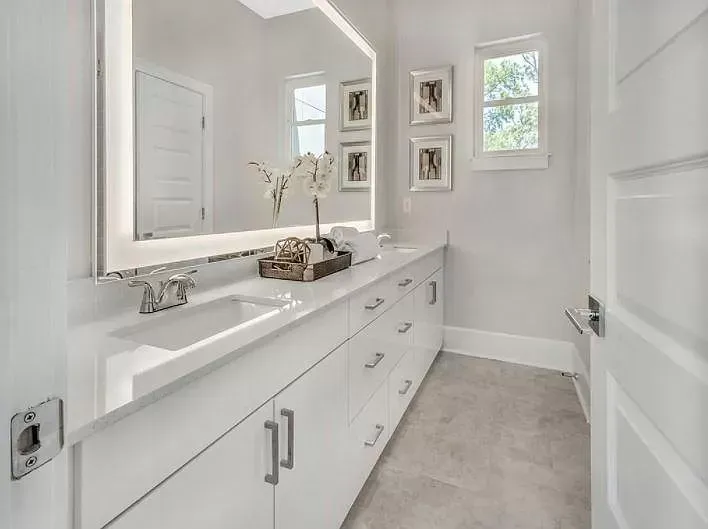A bathroom with two sinks and a large mirror.