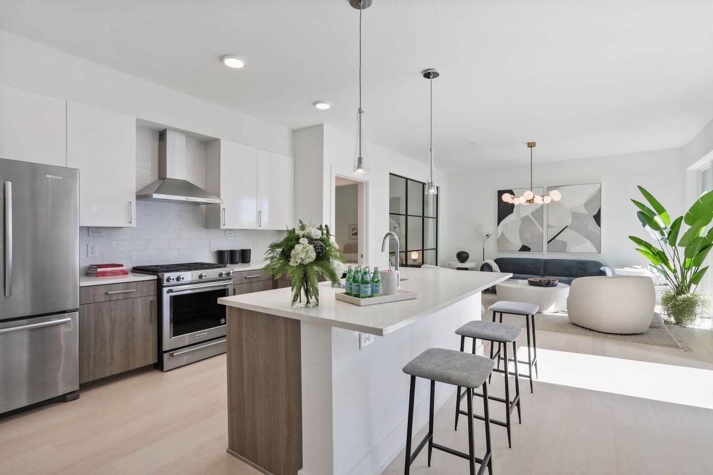 A kitchen with stainless steel appliances and a large island in the middle of the room.