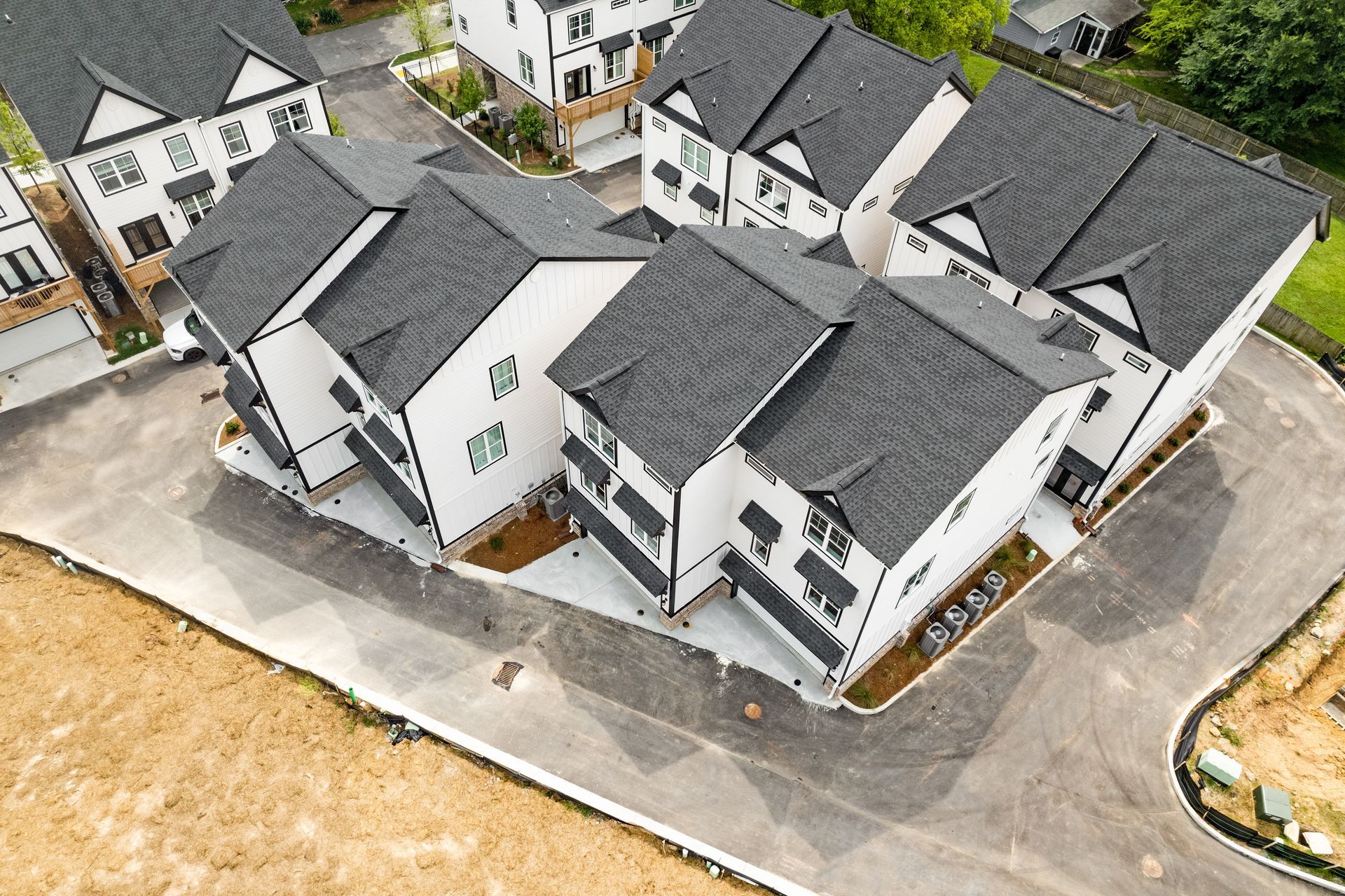 An aerial view of a row of houses with black roofs.