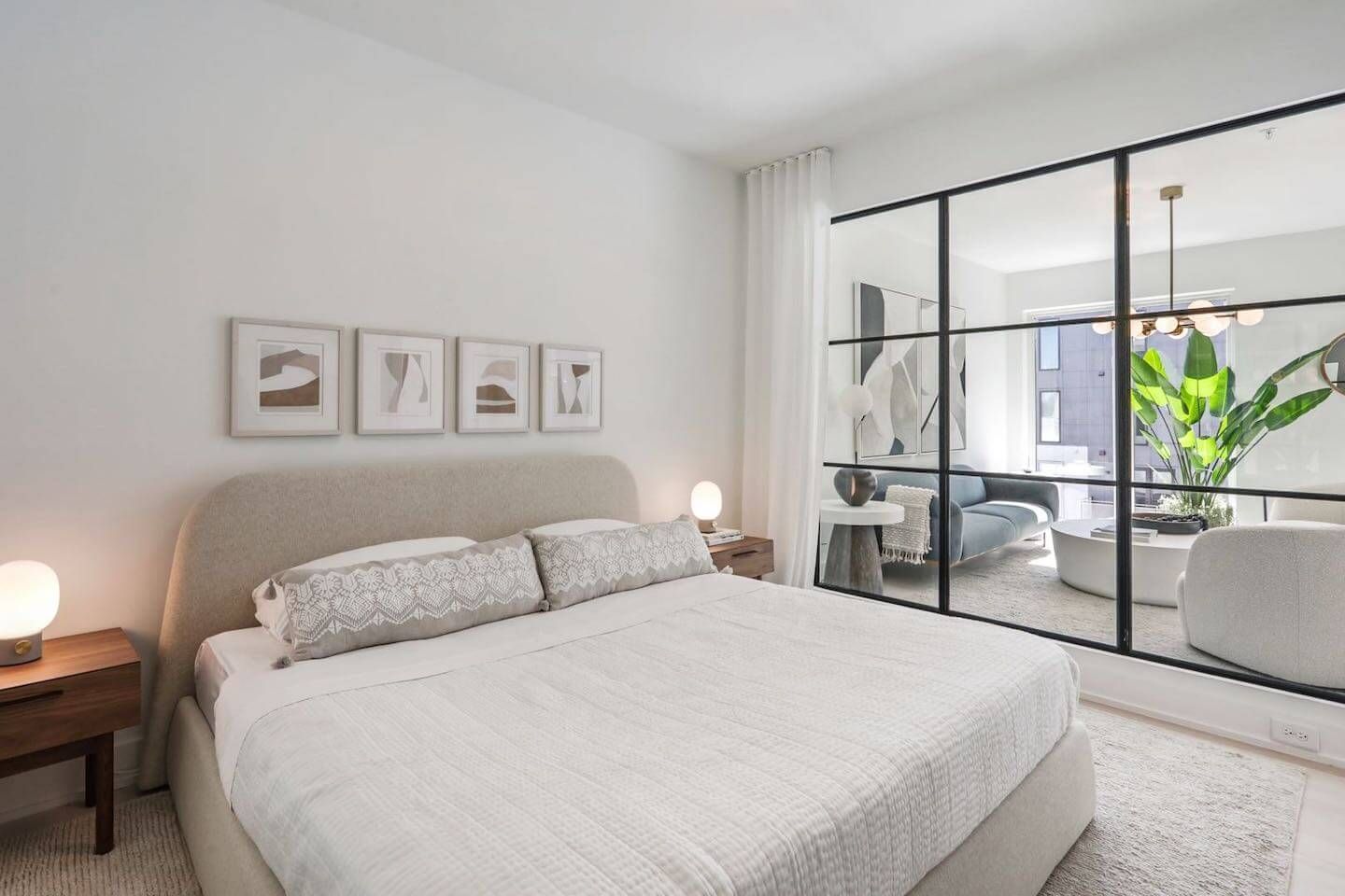 A bedroom with a large bed and a large mirror on the wall.