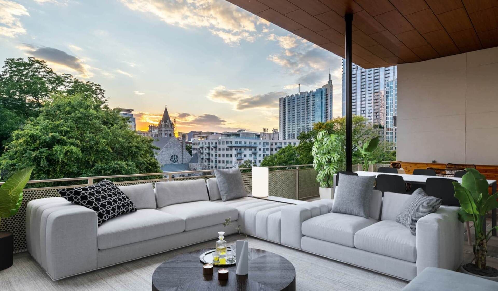 A living room with a couch and a table with a view of the city.