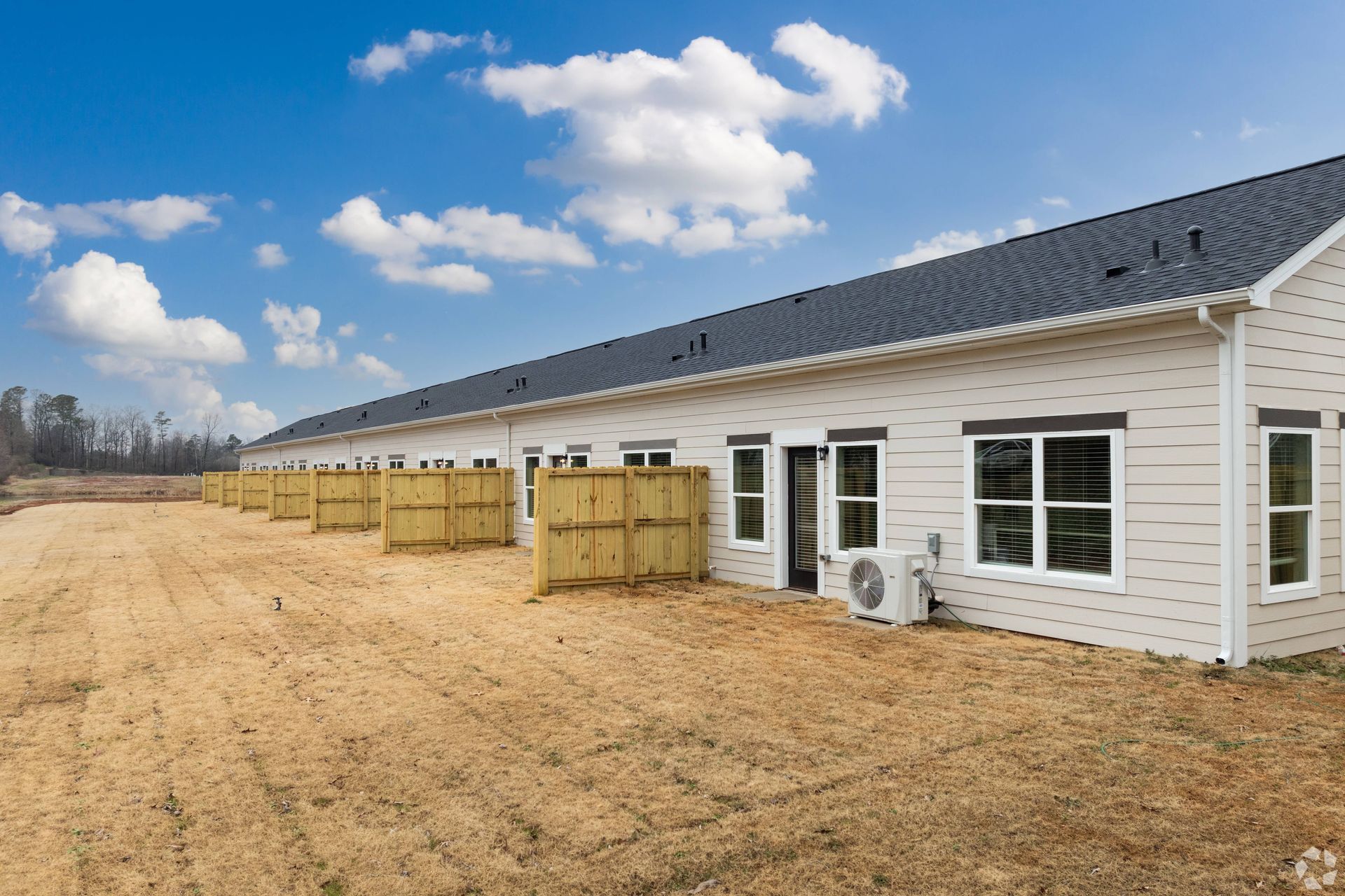 A row of houses are sitting next to each other in a field.
