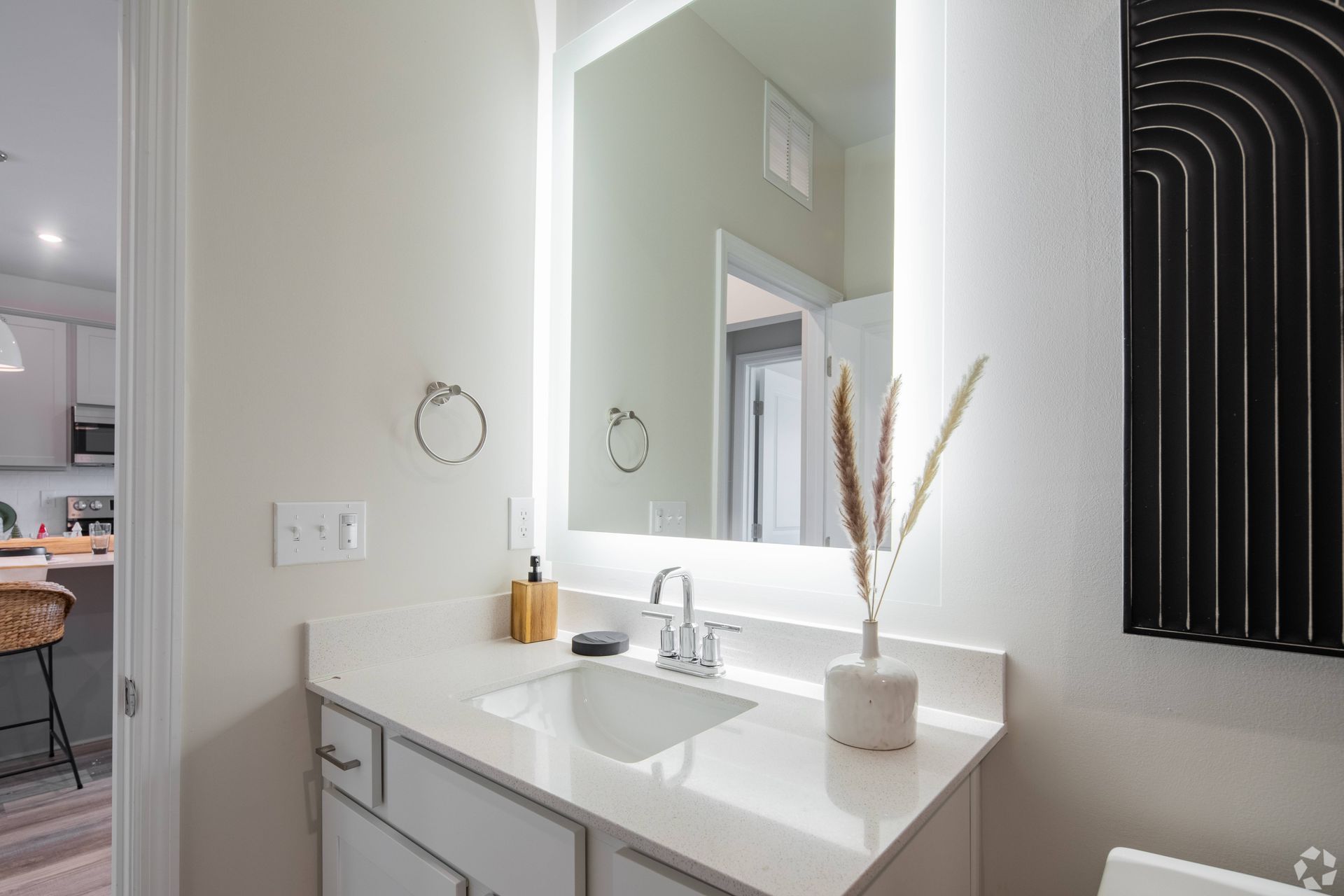 A bathroom with a sink , mirror and toilet.