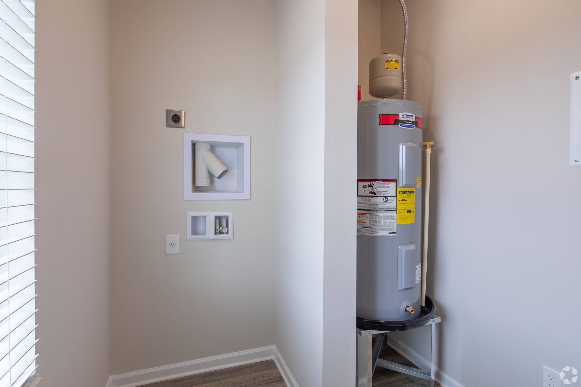 There is a water heater in the corner of the room.