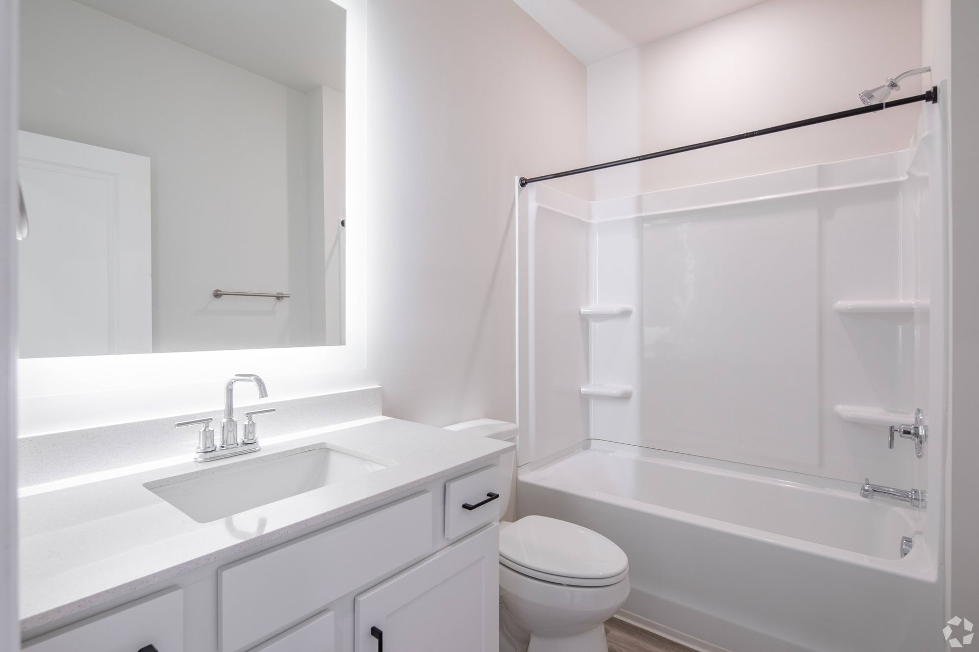 A bathroom with a sink , toilet , tub and mirror.