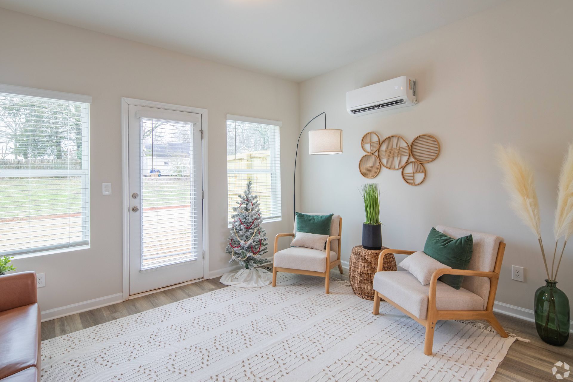 A living room with two chairs and a christmas tree.