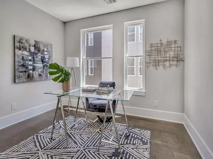 A home office with a glass desk and chair.