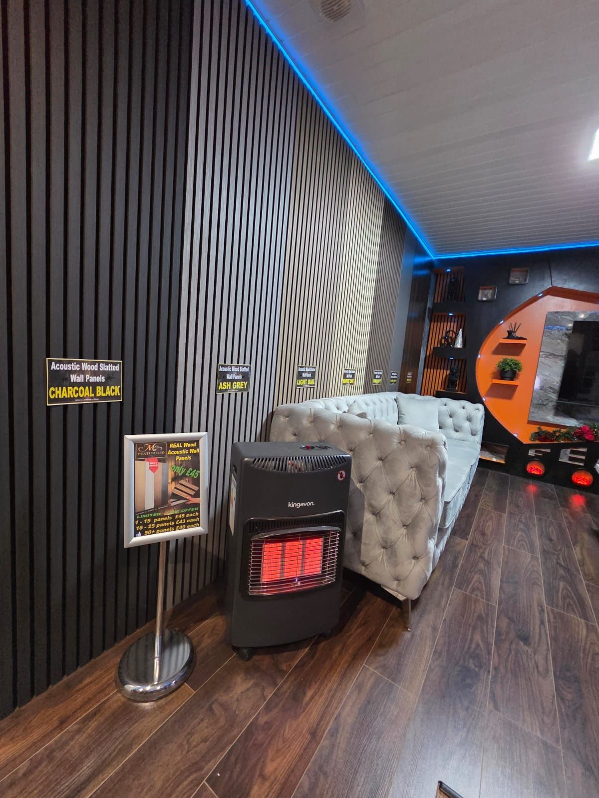 Room interior with a space heater, gray sofa, and modern wall decor.