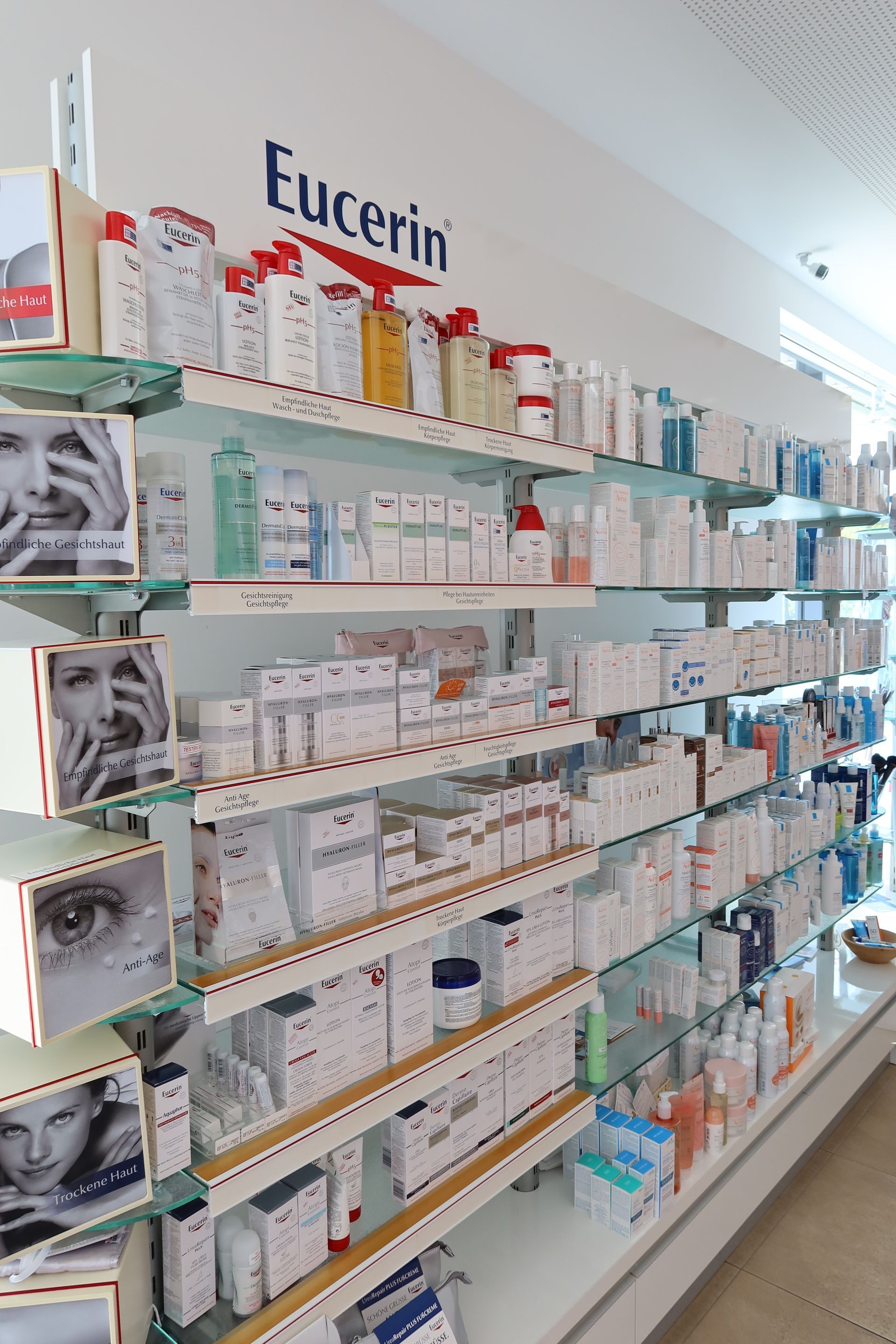 Regale mit verschiedenen Eucerin-Hautpflegeprodukten in einer Apotheke.