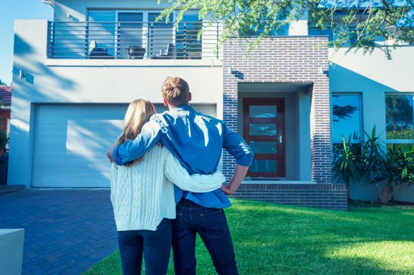 Couple standing in front of new home