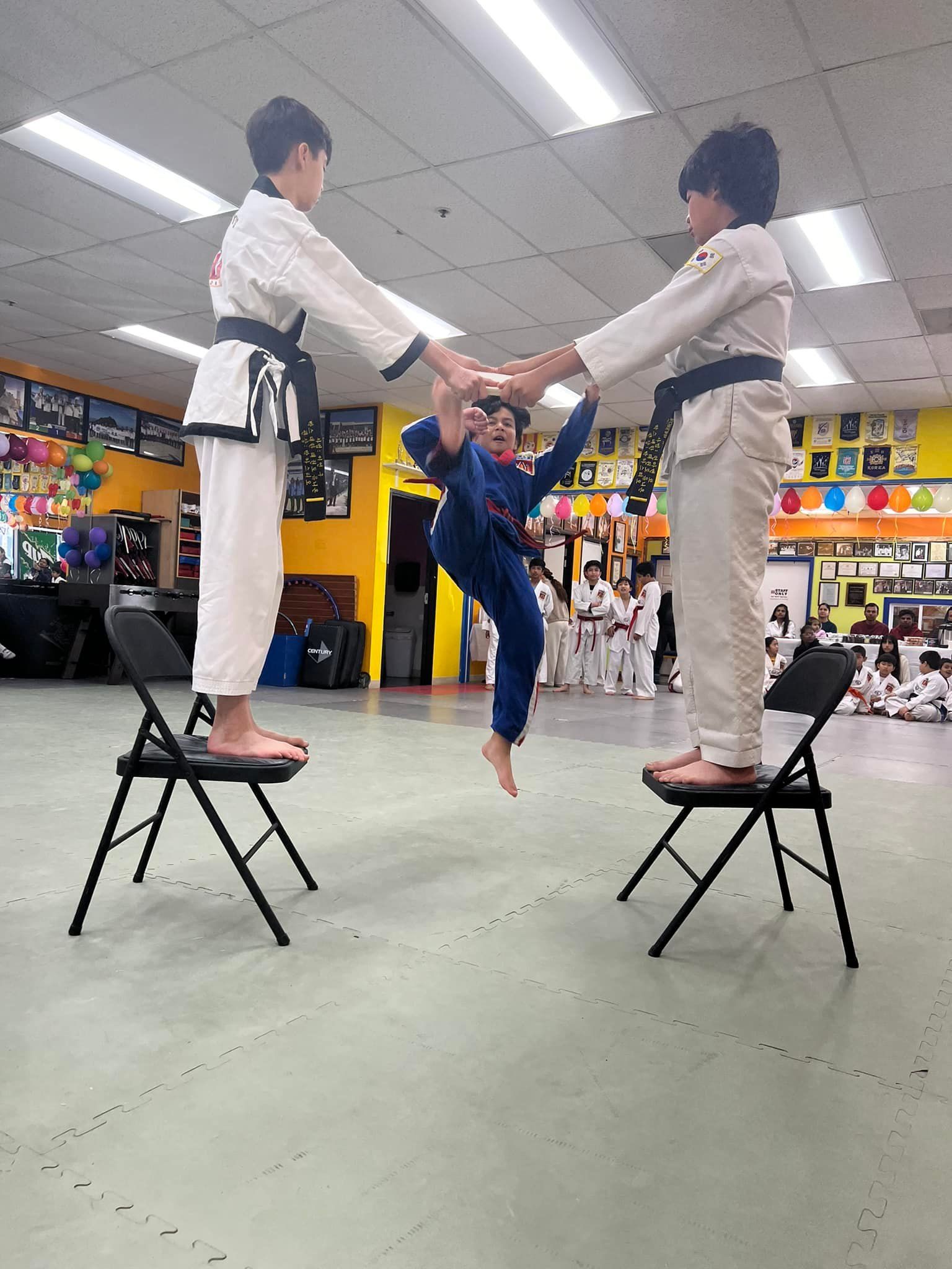 A group of young boys are practicing martial arts in a gym.