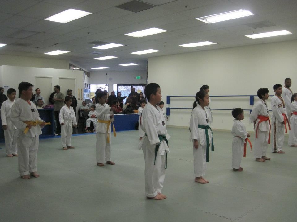 A group of children are practicing martial arts in a gym