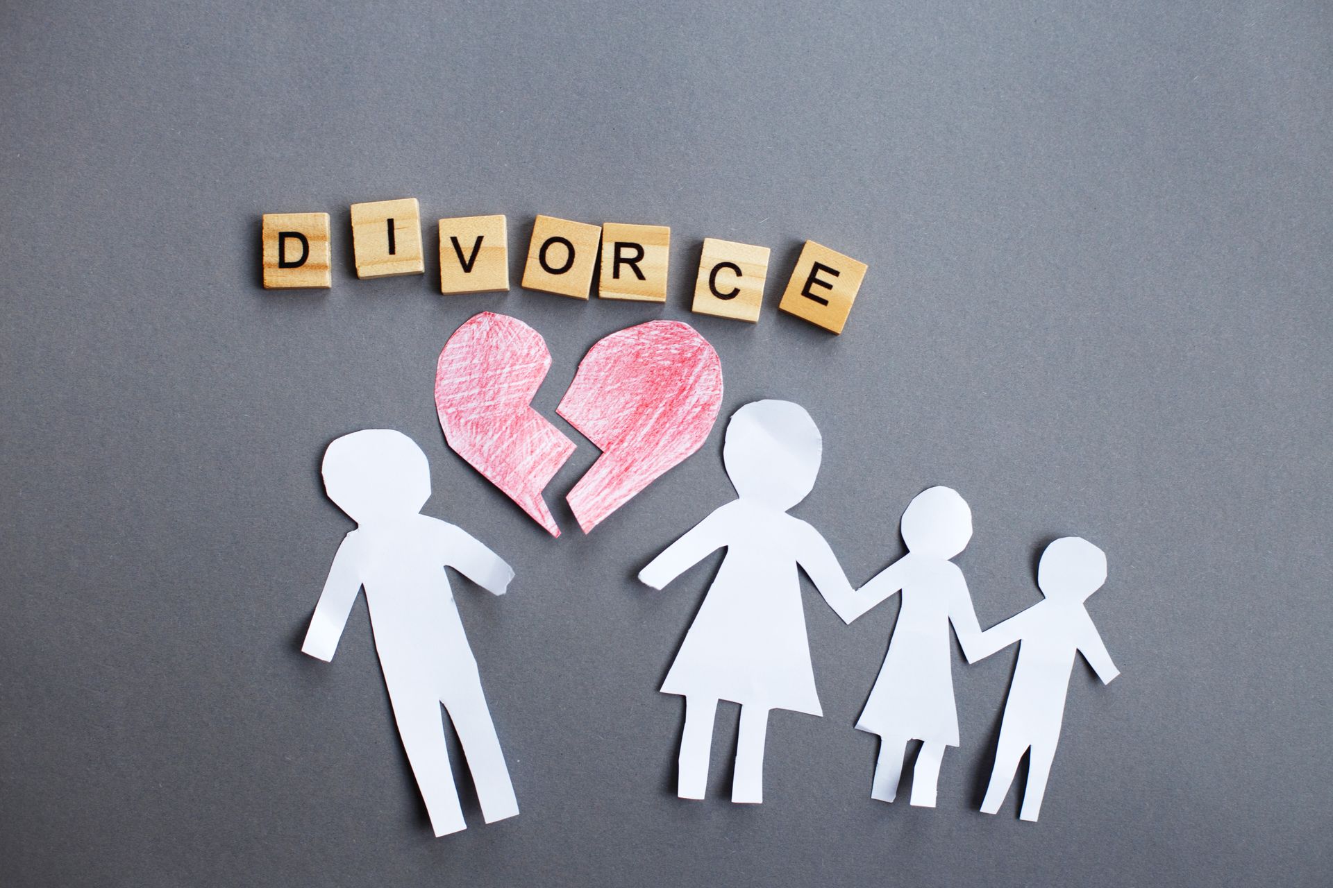 Paper cutout family with a broken heart symbolizing an amicable divorce and its impact on families.
