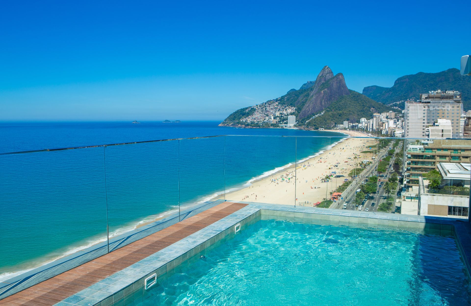 Há uma piscina no telhado de um prédio com vista para o oceano. Sol Ipanema Hotel
