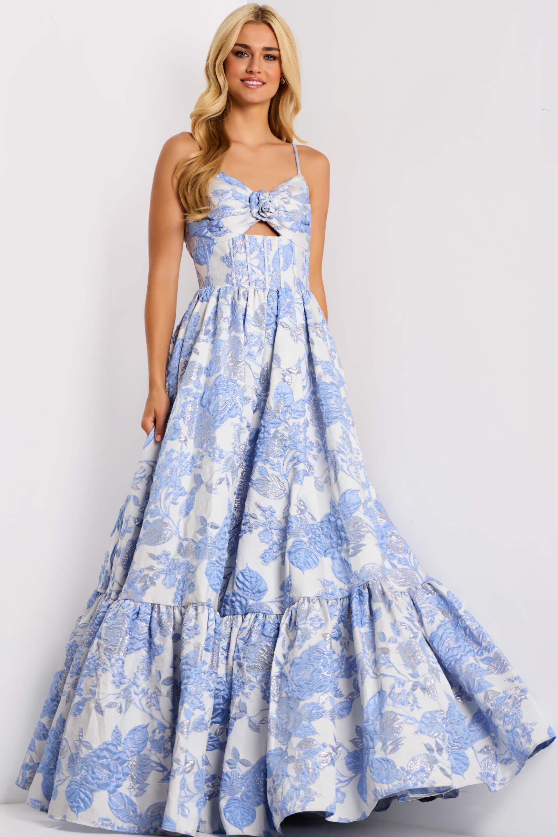 Woman wearing a blue and white floral print gown with a keyhole detail, standing.