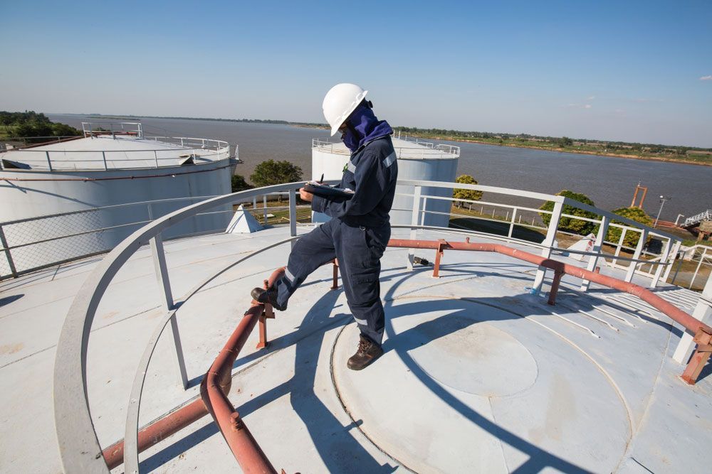 A Man in a Hard Hat is Standing on Top of a Large Tank — Hinterland Water Cartage in Mooloolah Valley, QLD