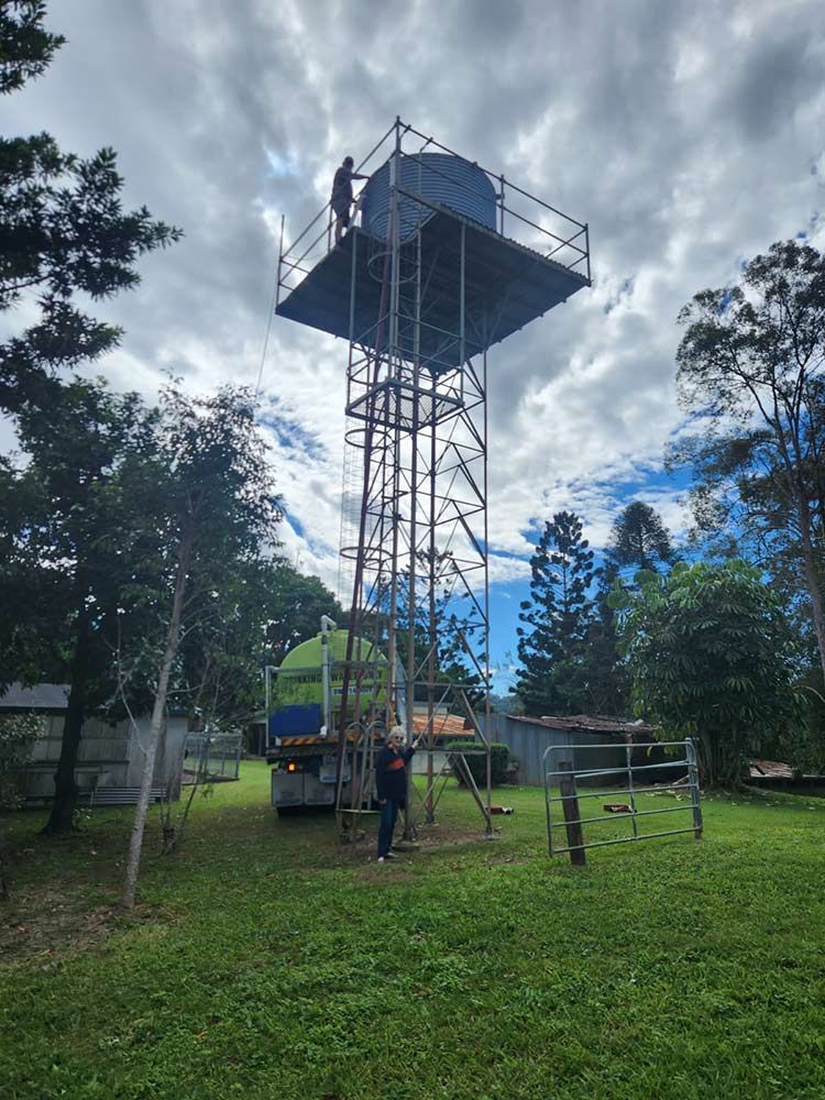 A Man is Standing on Top of a Water Tower — Hinterland Water Cartage in Mooloolah Valley, QLD