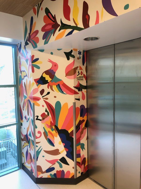 An elevator with a colorful mural on the wall