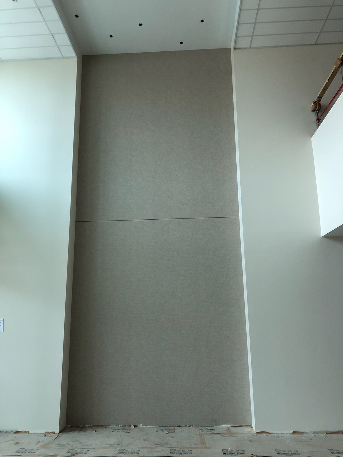 A large white wall with a ceiling in a room