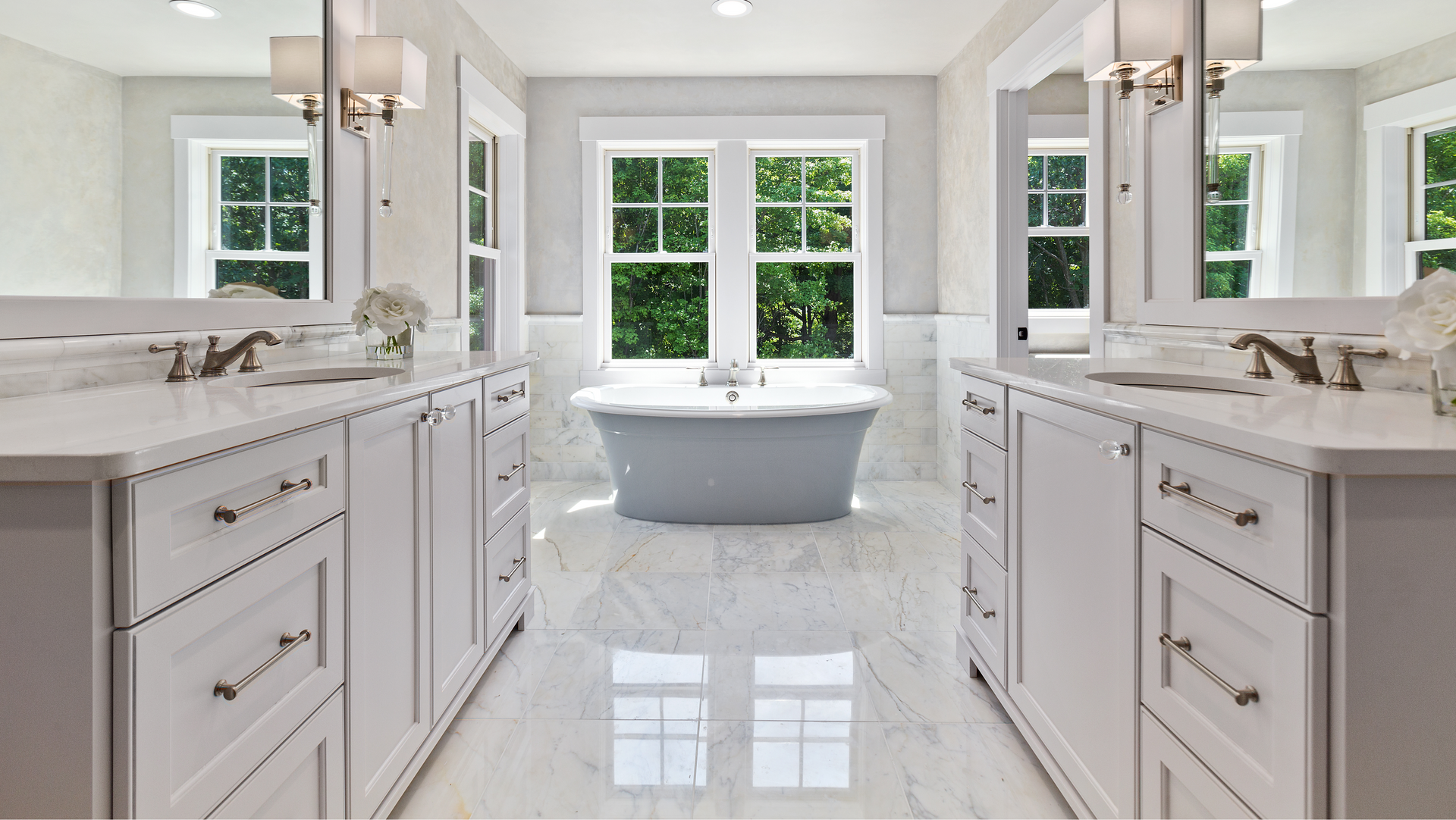A bathroom with two sinks , two mirrors and a bathtub.