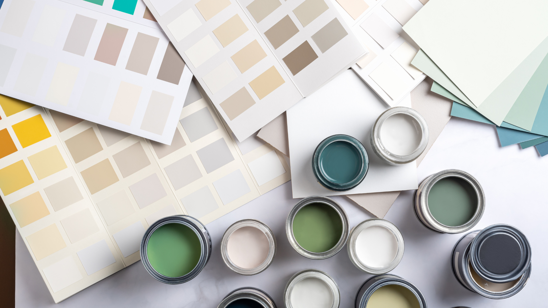 A bunch of paint cans and samples of paint on a table.