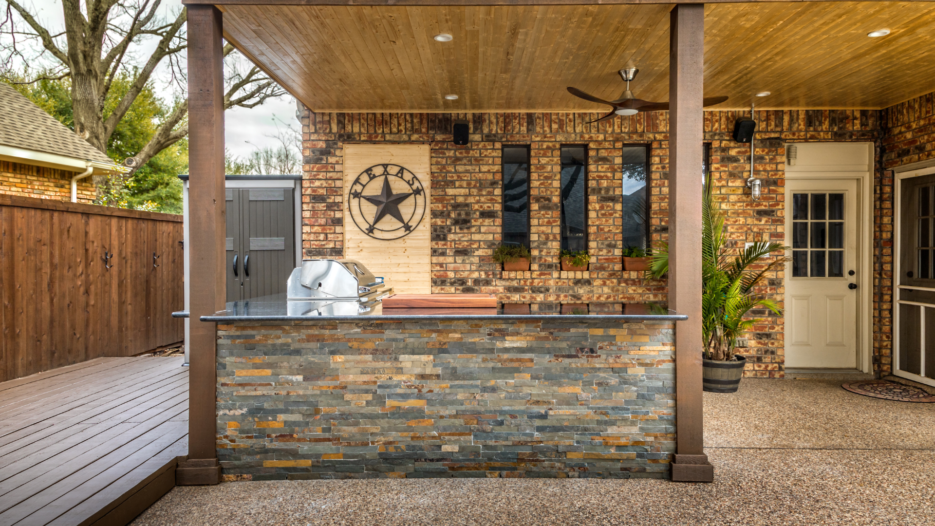 A patio with a brick wall and a stone counter top.
