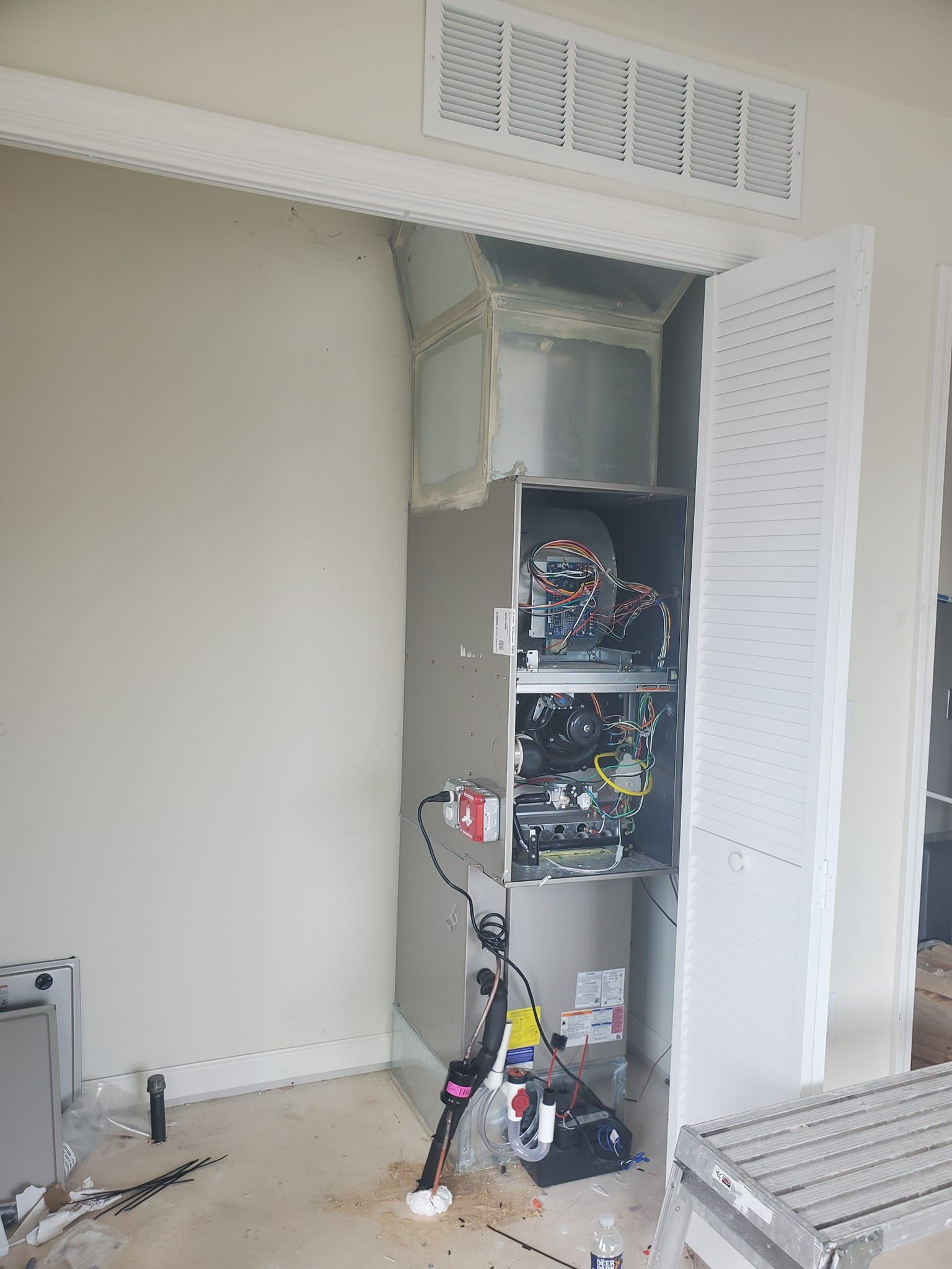 A room with a closet and a furnace in it.