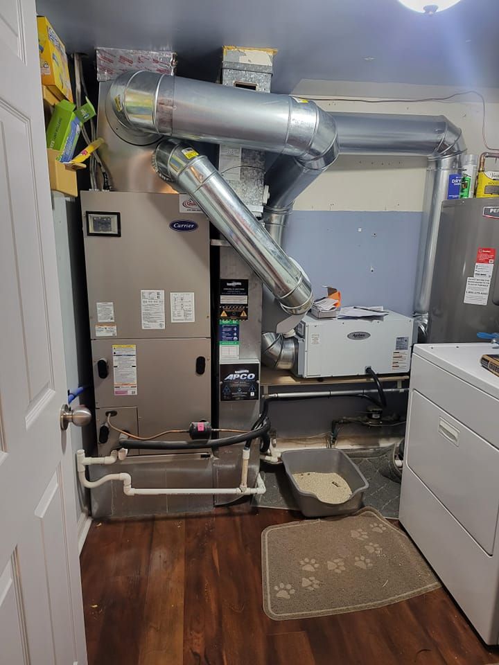 A laundry room with a cat litter box and a washer and dryer.