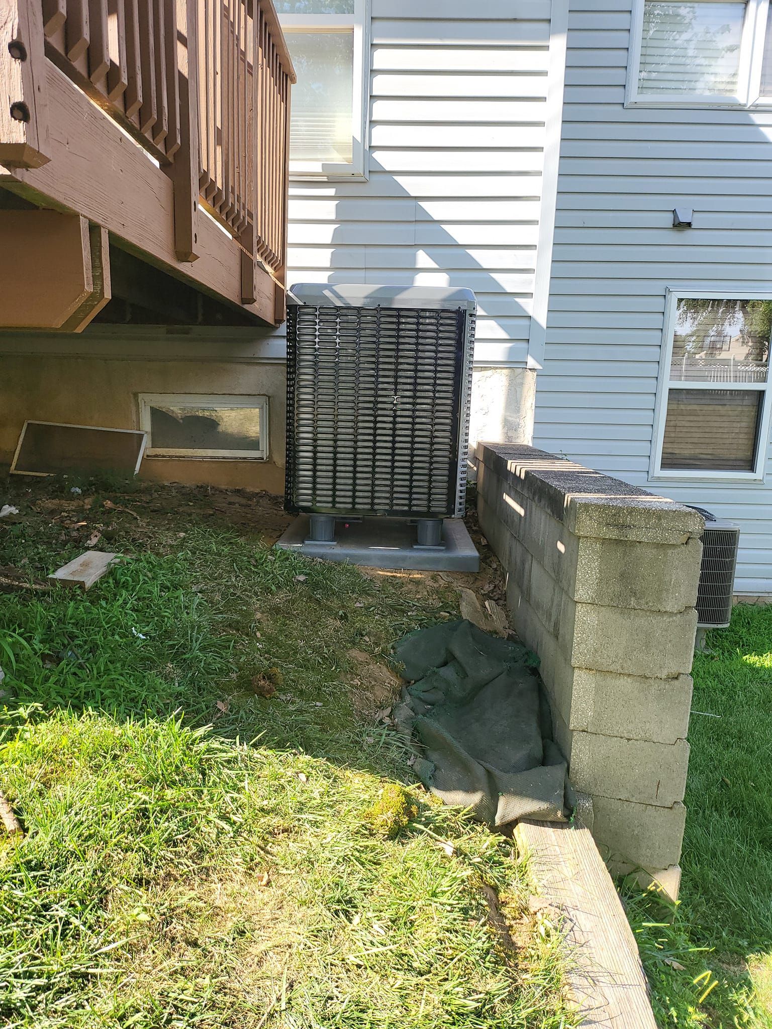 A house with a deck and a concrete wall in front of it.