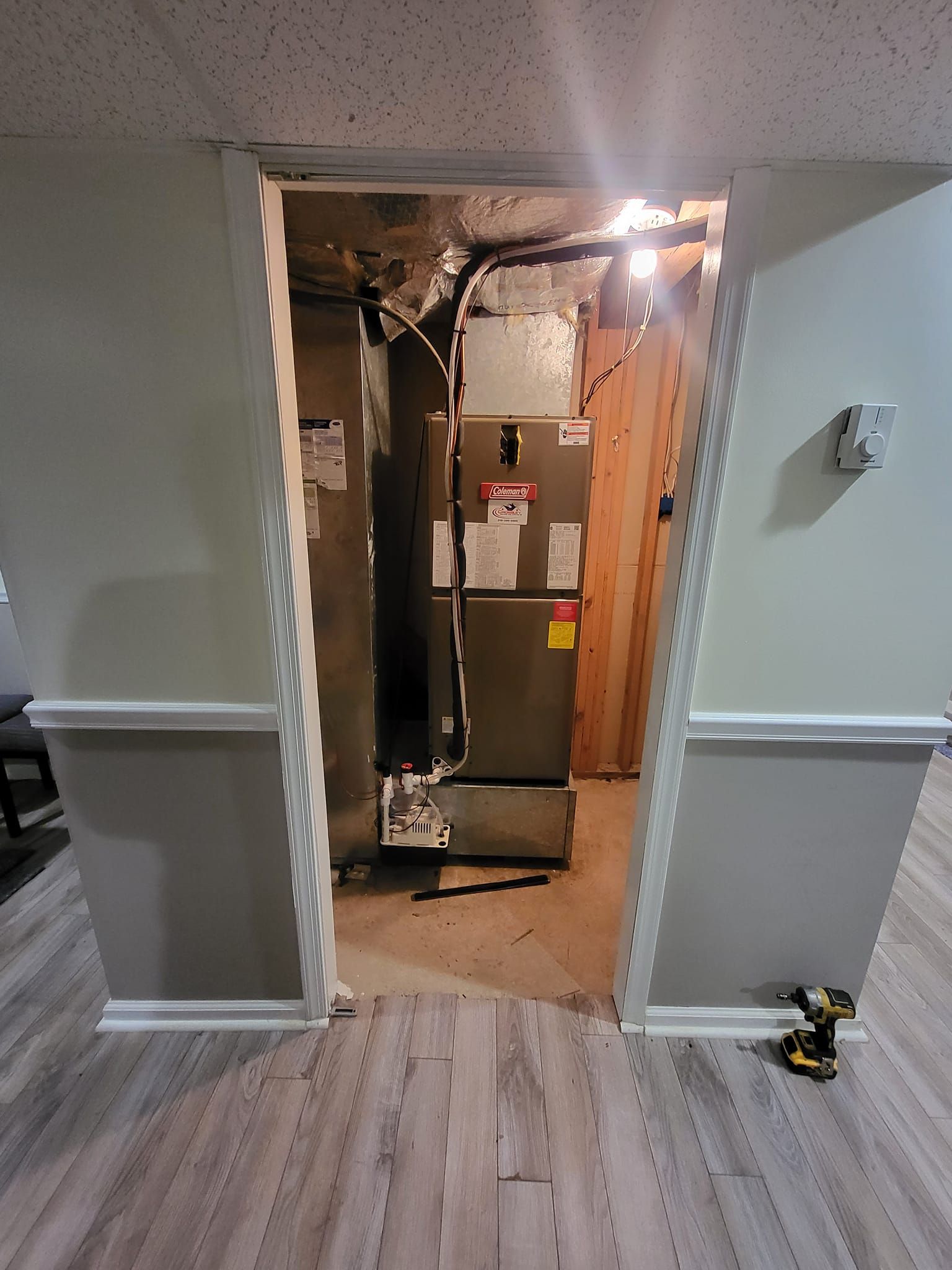 A room with a refrigerator and a furnace in it.