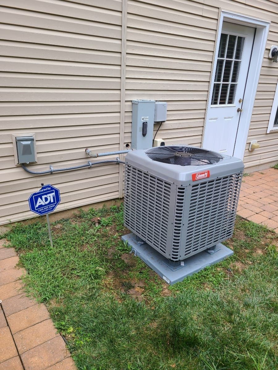 An air conditioner is sitting on the side of a house.