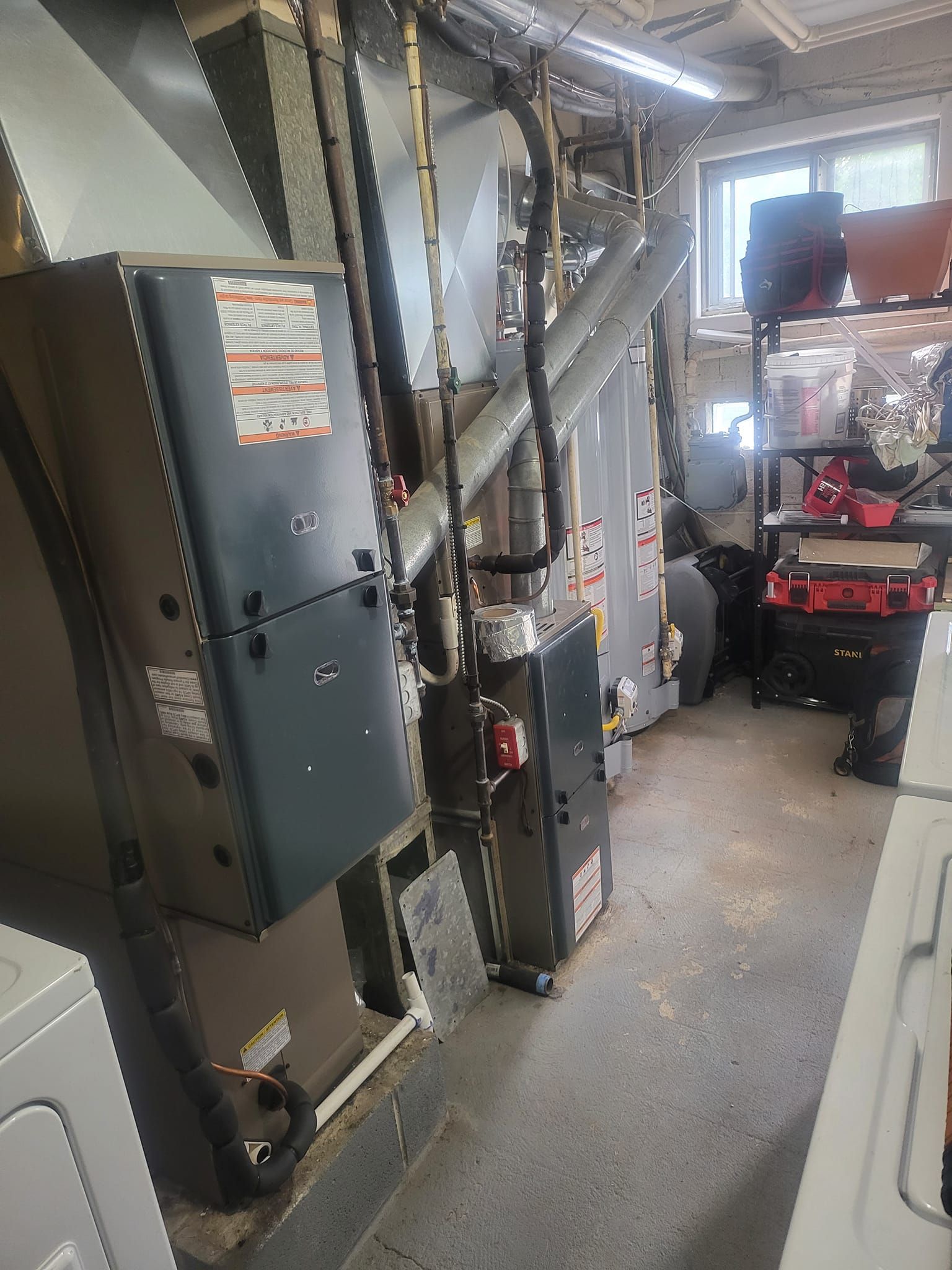 A room with a lot of appliances in it , including a washer and dryer.