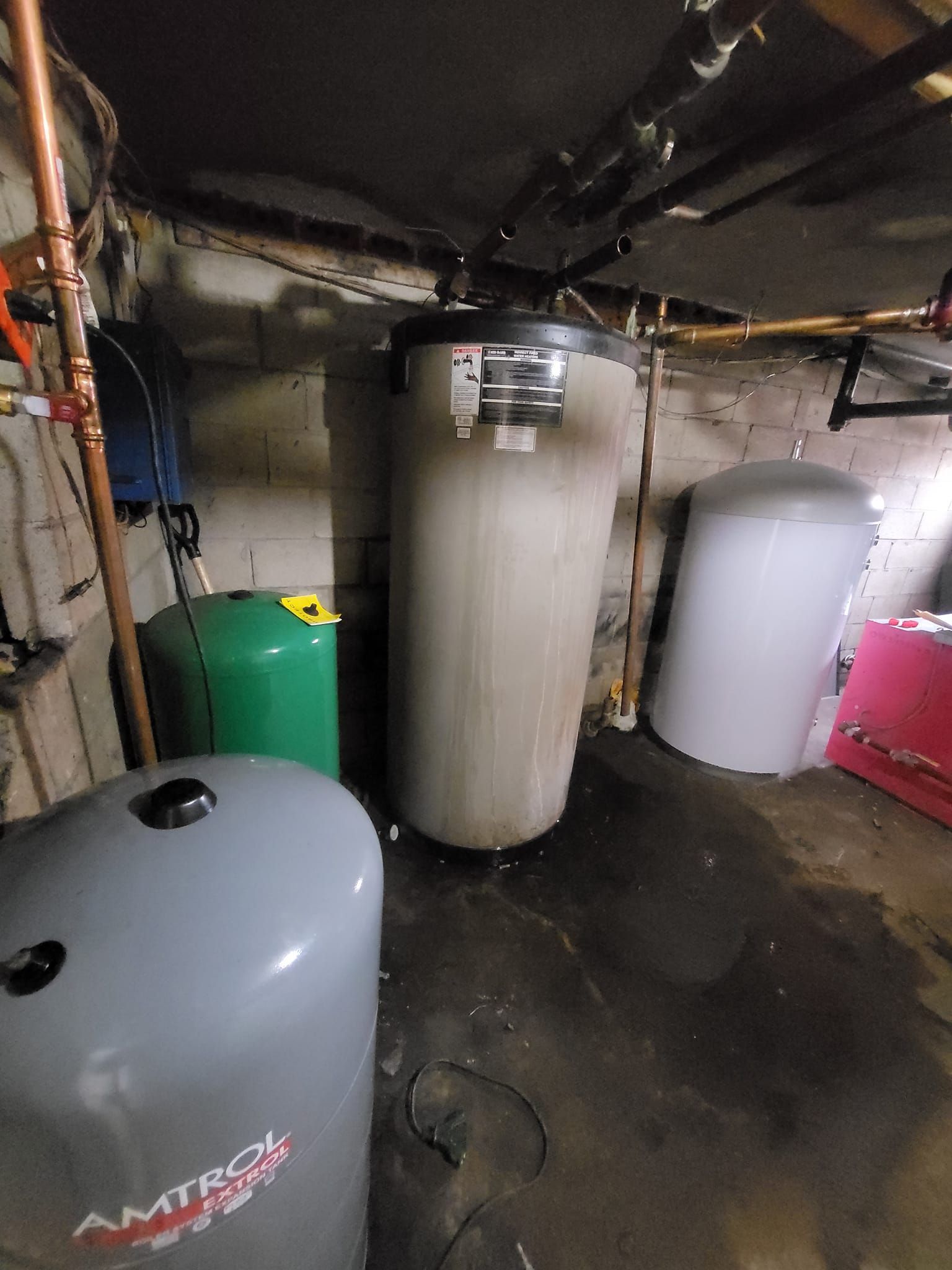 A bunch of water heaters are sitting in a basement.