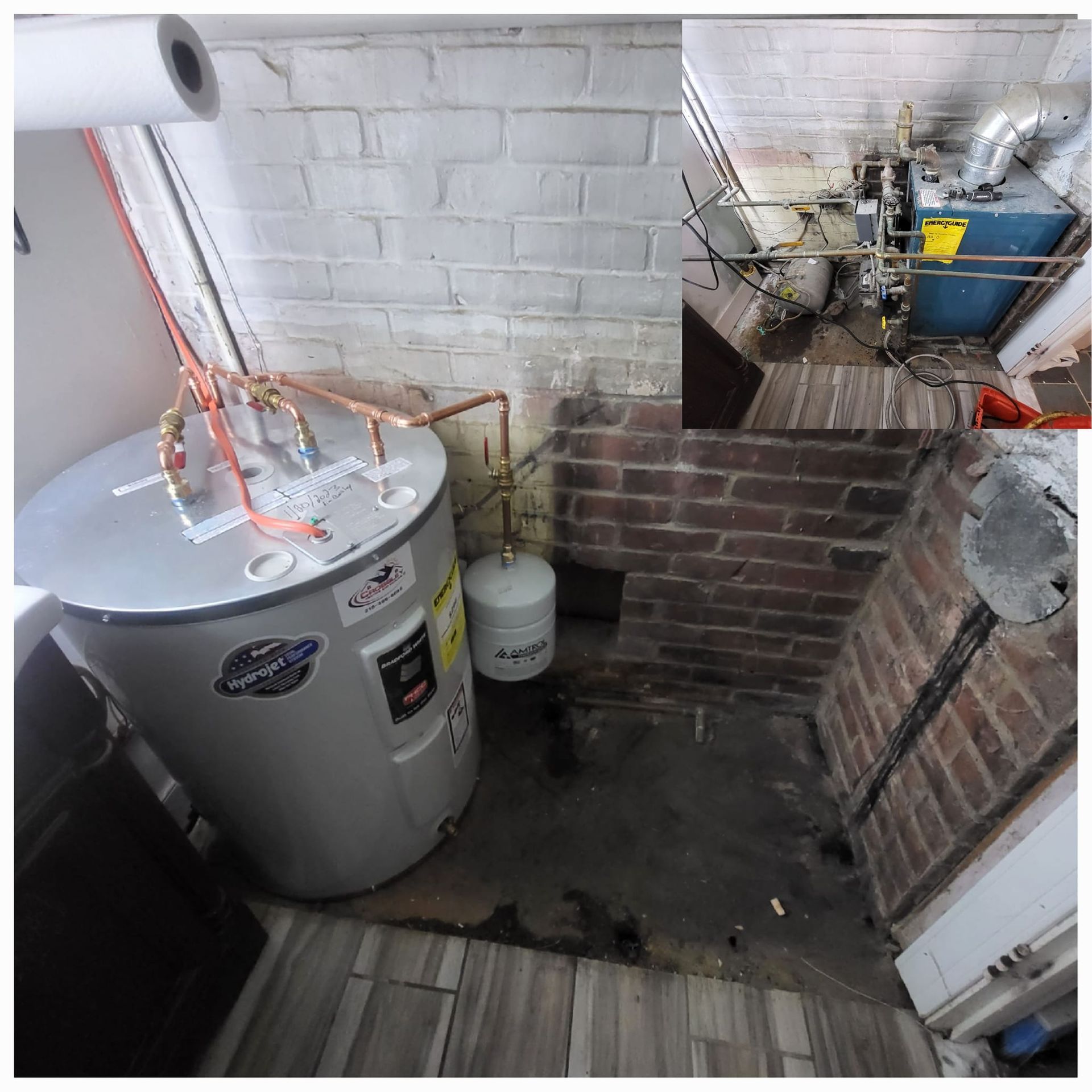 A water heater is sitting in a room next to a brick wall.