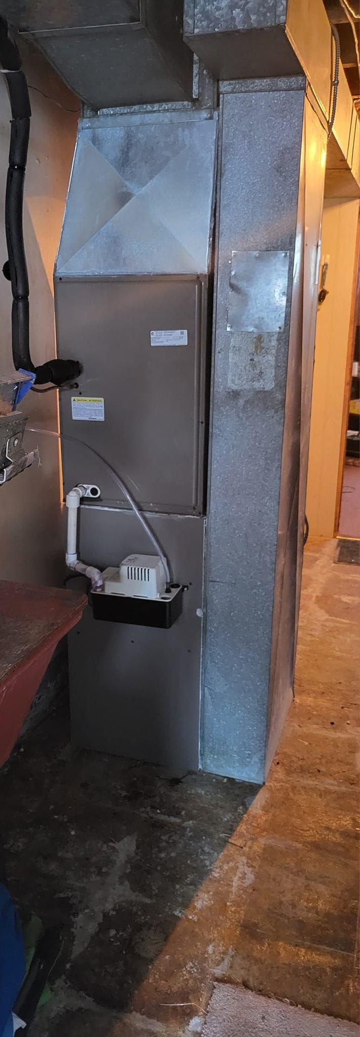 A stainless steel air conditioner is sitting in a room next to a wall.