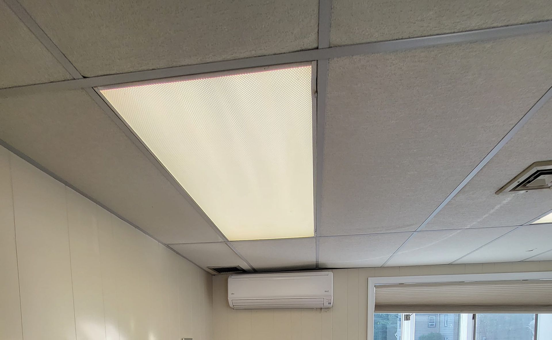 A room with a ceiling fan and a window.