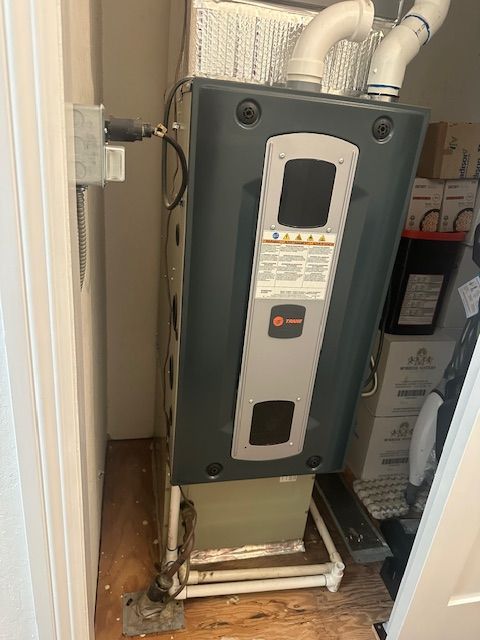 An air conditioner is sitting in a closet next to a door.