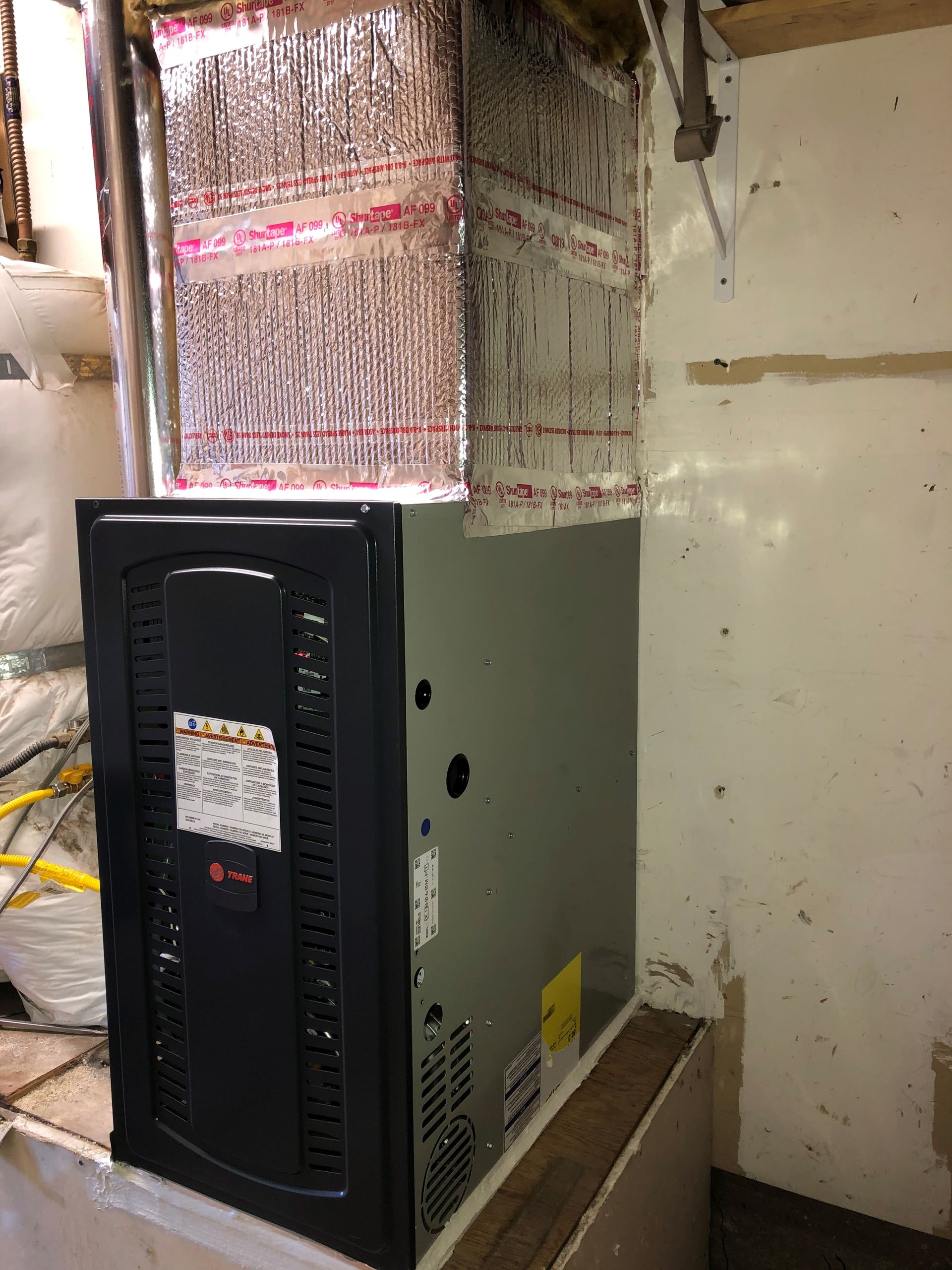 An air conditioner is sitting on top of a wooden table in a room.