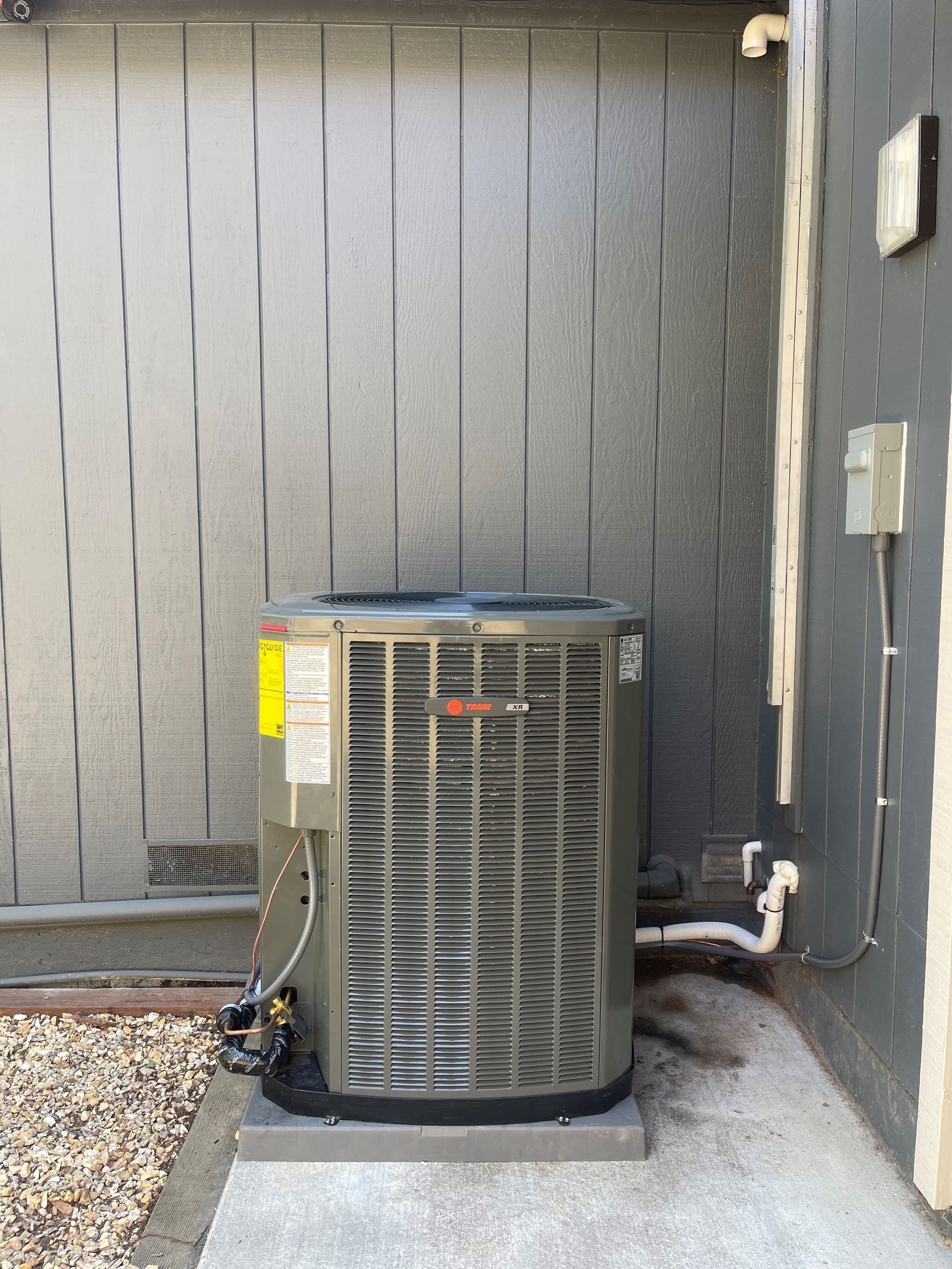 An air conditioner is sitting on the side of a building.