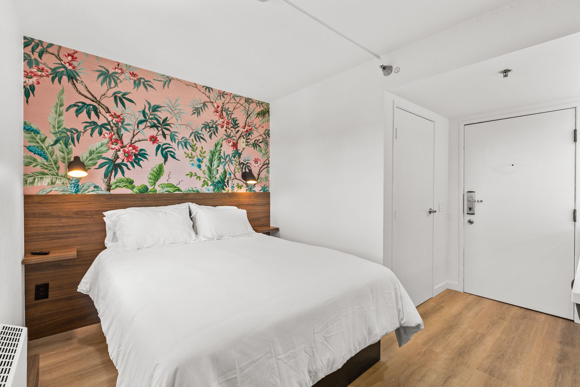 A hotel room with a bed and a door