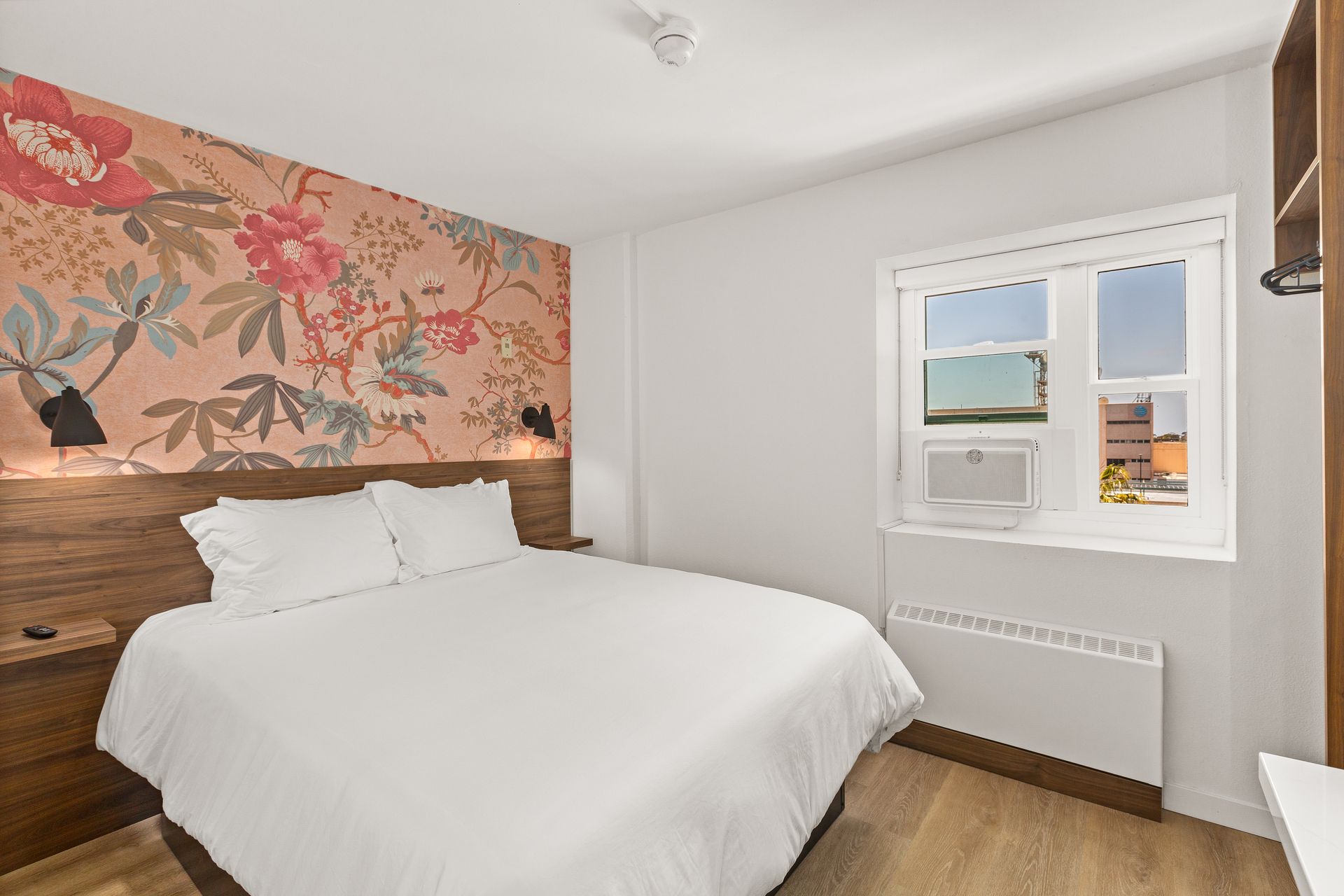 A hotel room with a king size bed and a window.
