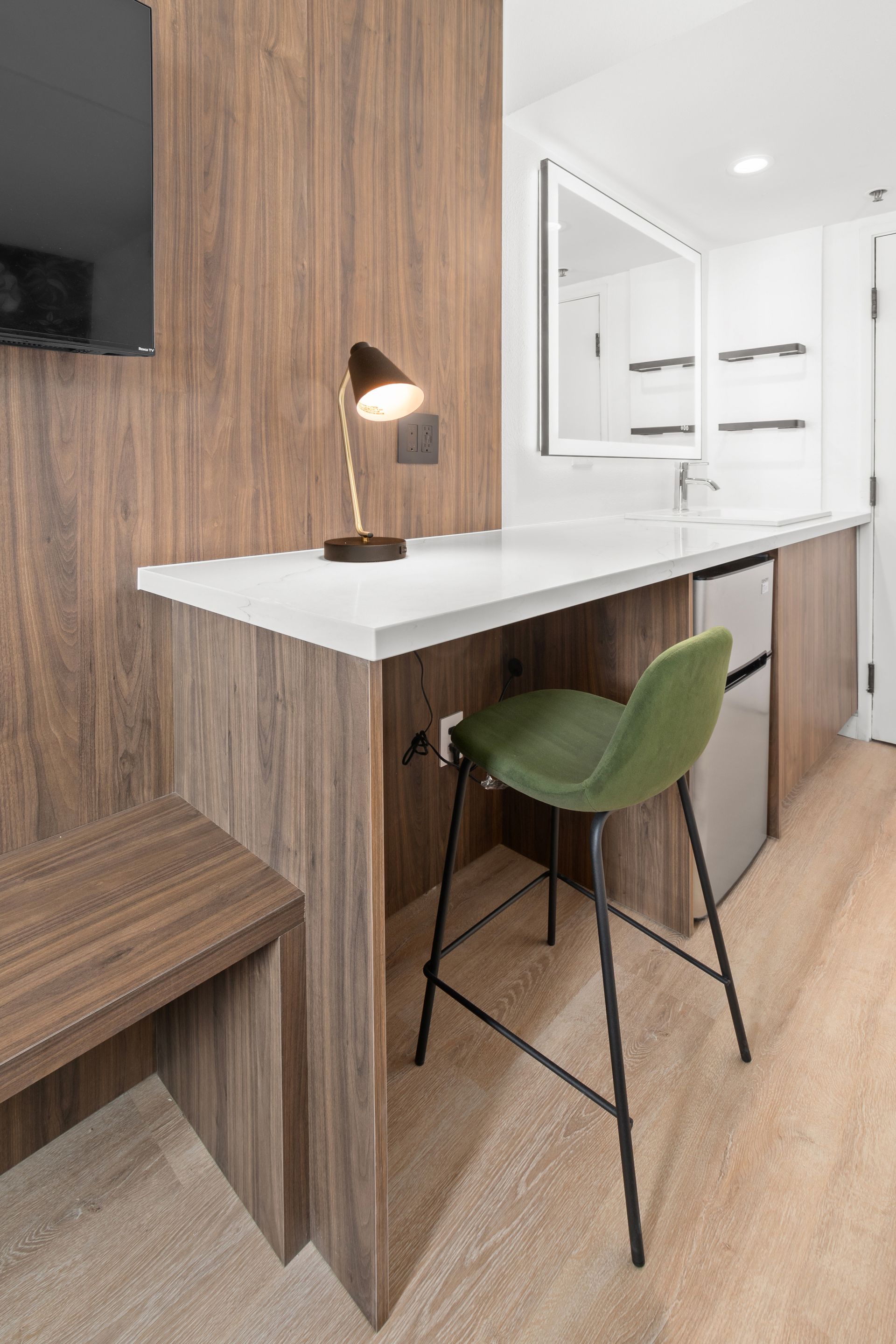 A kitchen with a table , chair , lamp and television.