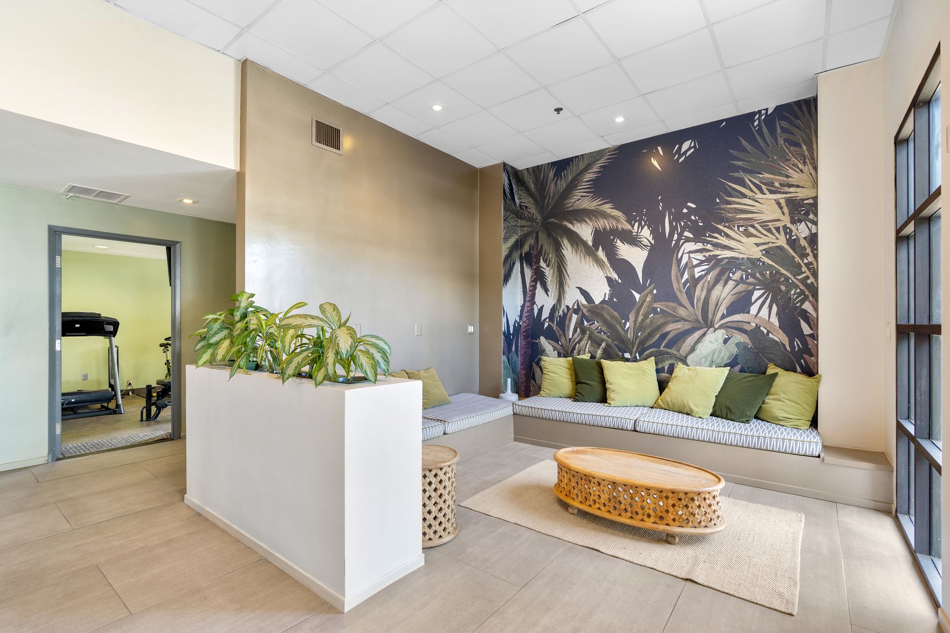 A living room with a couch , table , and a treadmill.