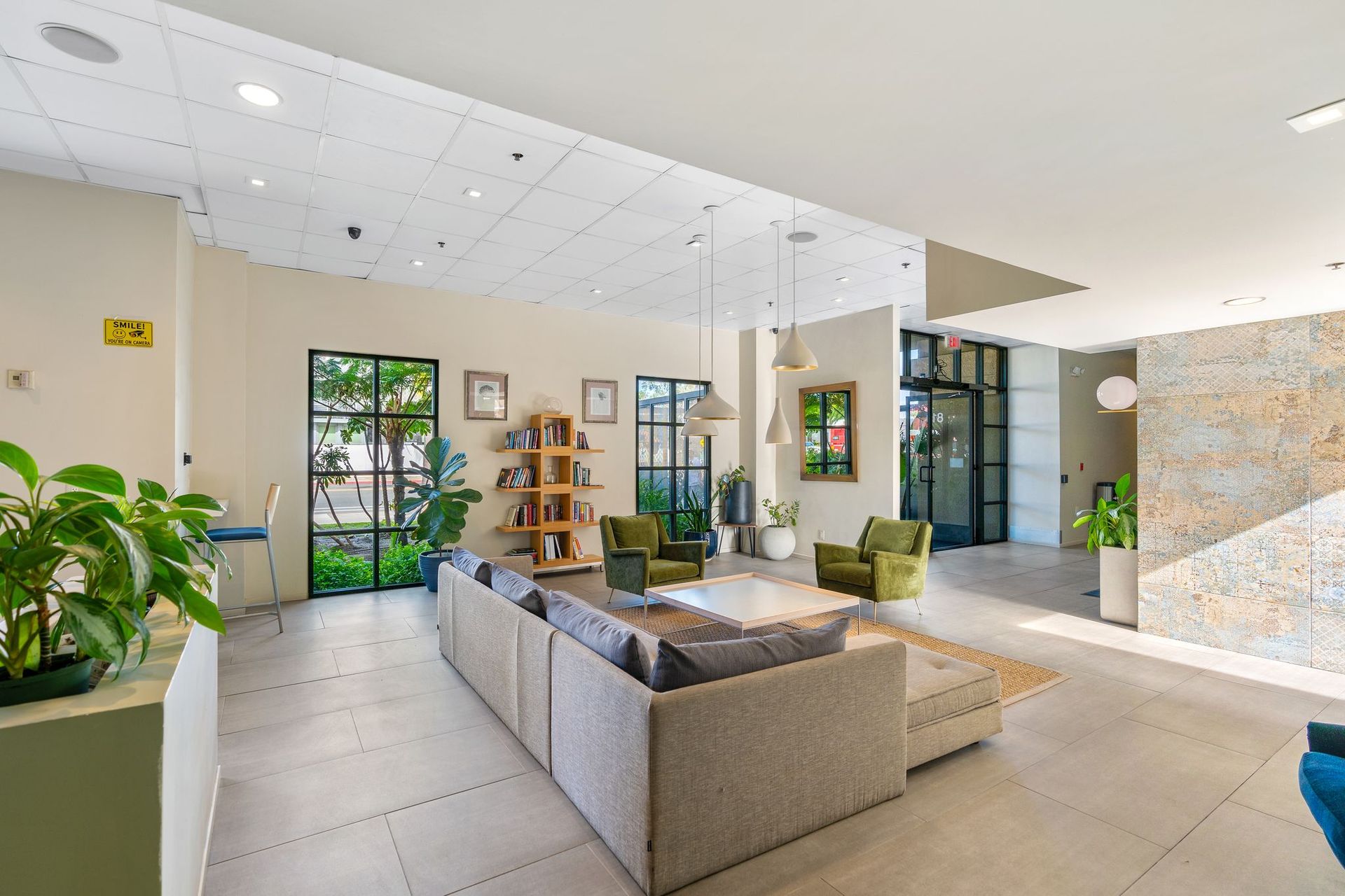 A living room with a couch , chairs , and a bookshelf.