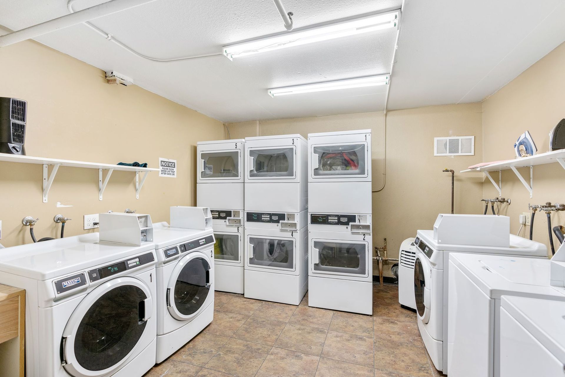 A laundromat with a lot of washers and dryers stacked on top of each other.