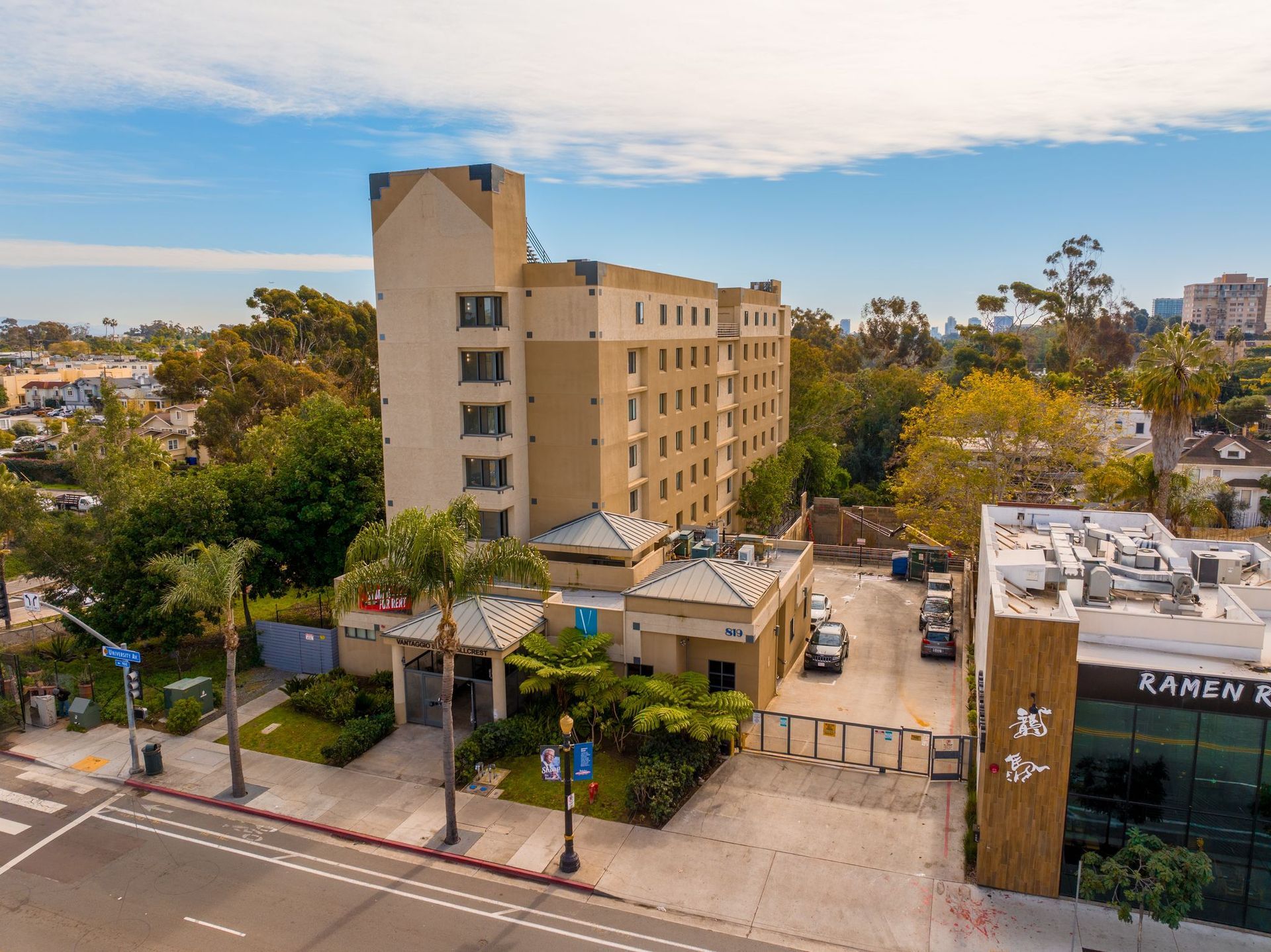 An aerial view of a large building with a lot of cars parked in front of it