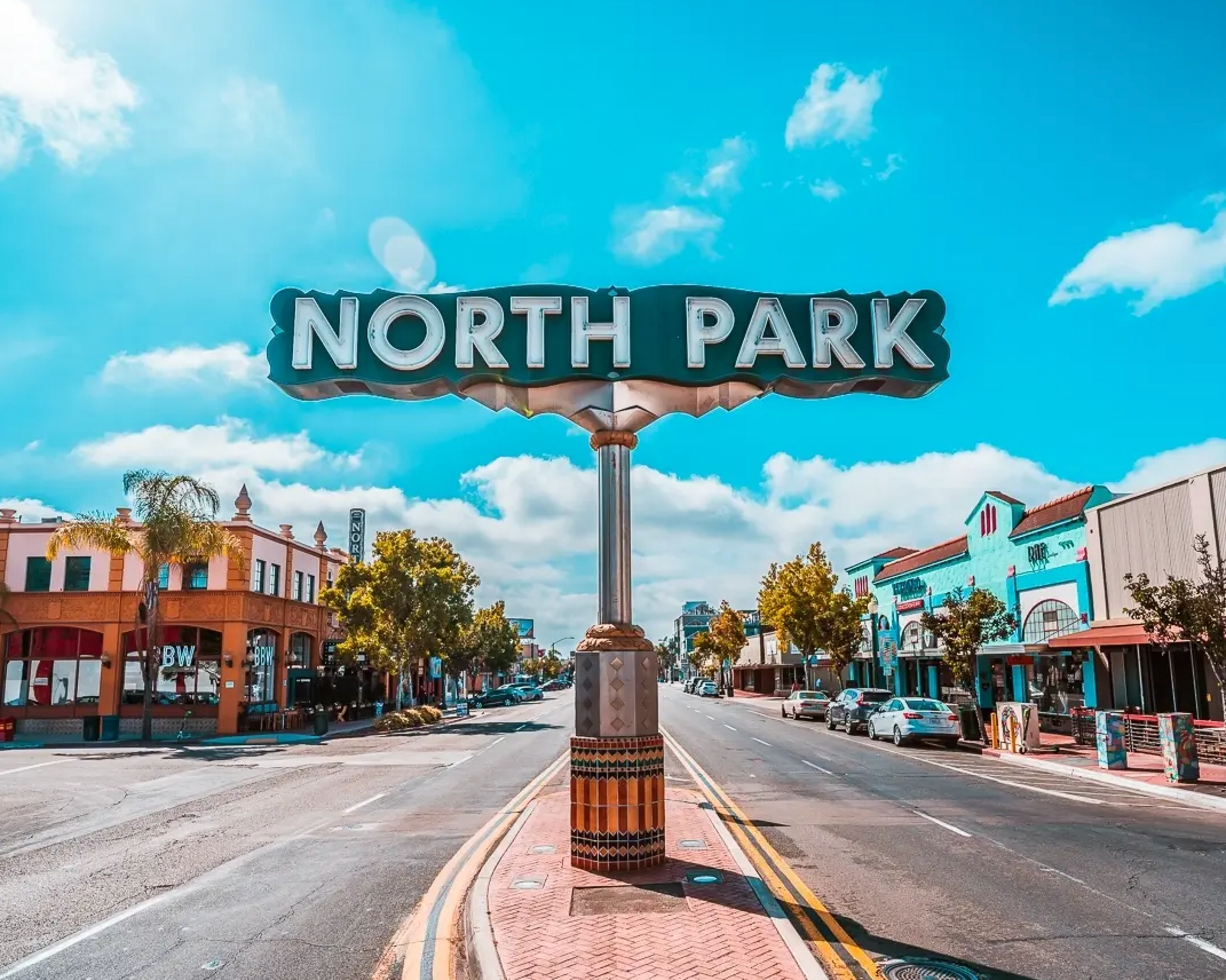 A sign for north park is sitting on the side of a city street.