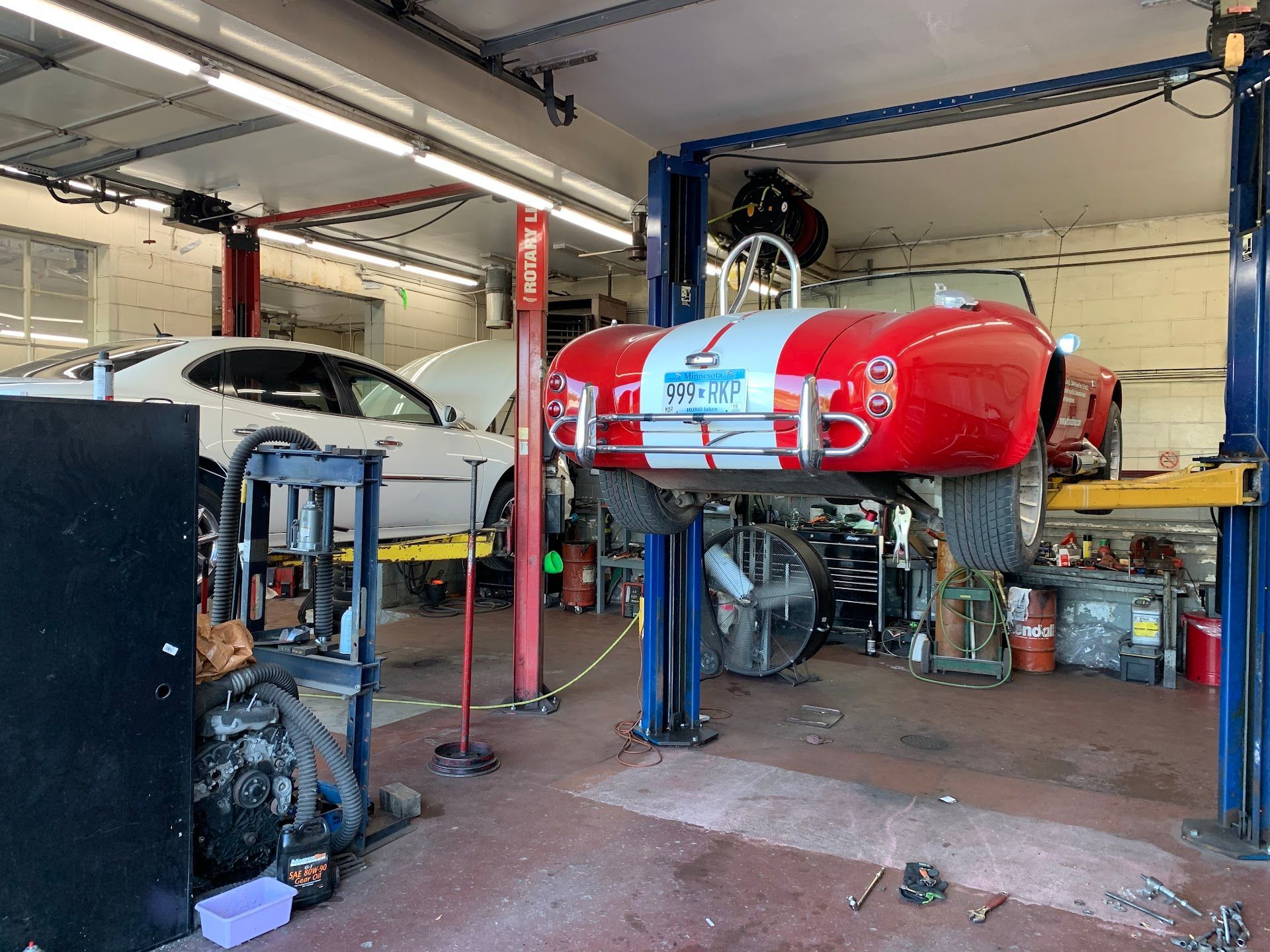A Red and White Sports Car Is on a Lift in a Garage | Wilson's Auto World